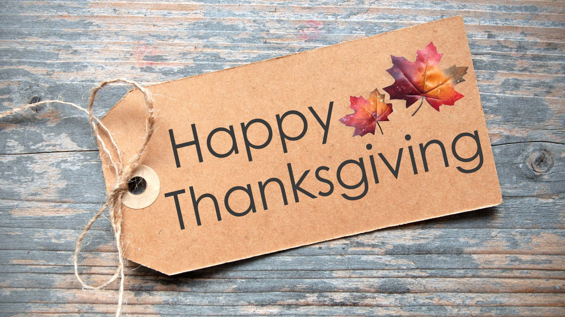 Happy Thanksgiving Tag With Leaves On A Wooden Background Wallpaper
