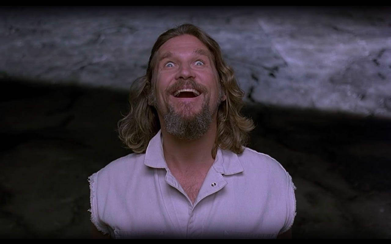 The Dude, the quirky character from the cult-classic film, The Big Lebowski, looking happy in an iconic movie scene. Wallpaper