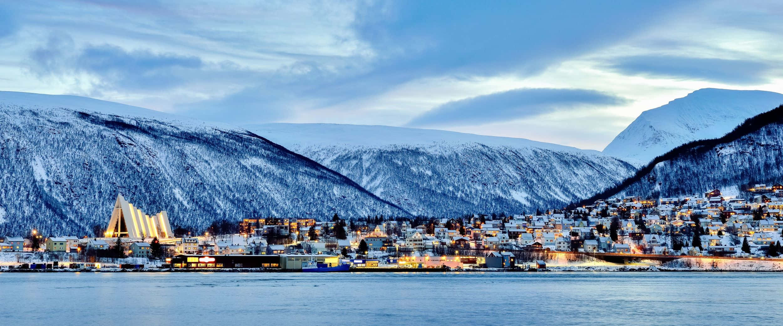 The Gleaming Cityscape Of Tromsø Under The Northern Lights Wallpaper