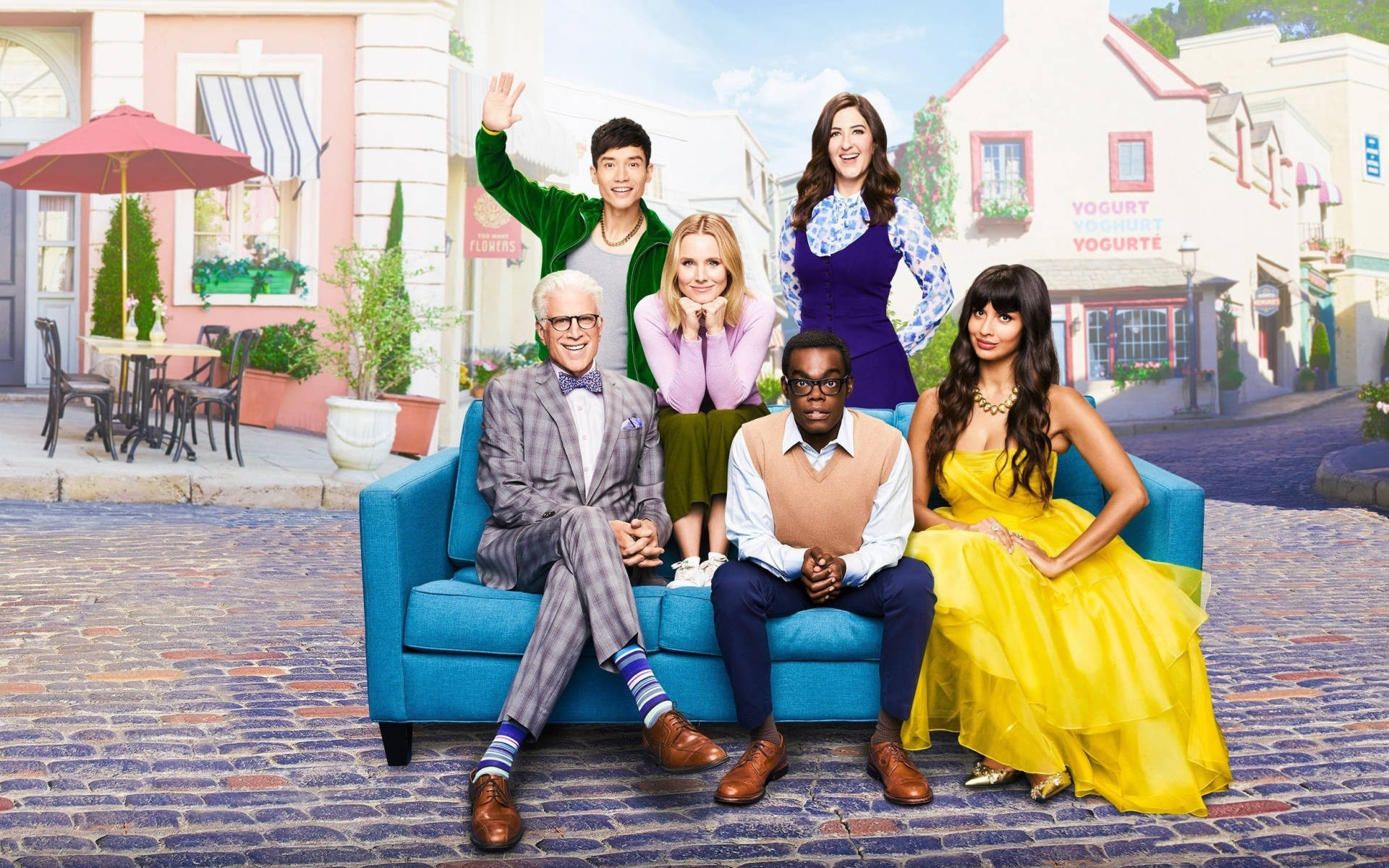 Main cast of The Good Place posing on a stylish blue couch Wallpaper