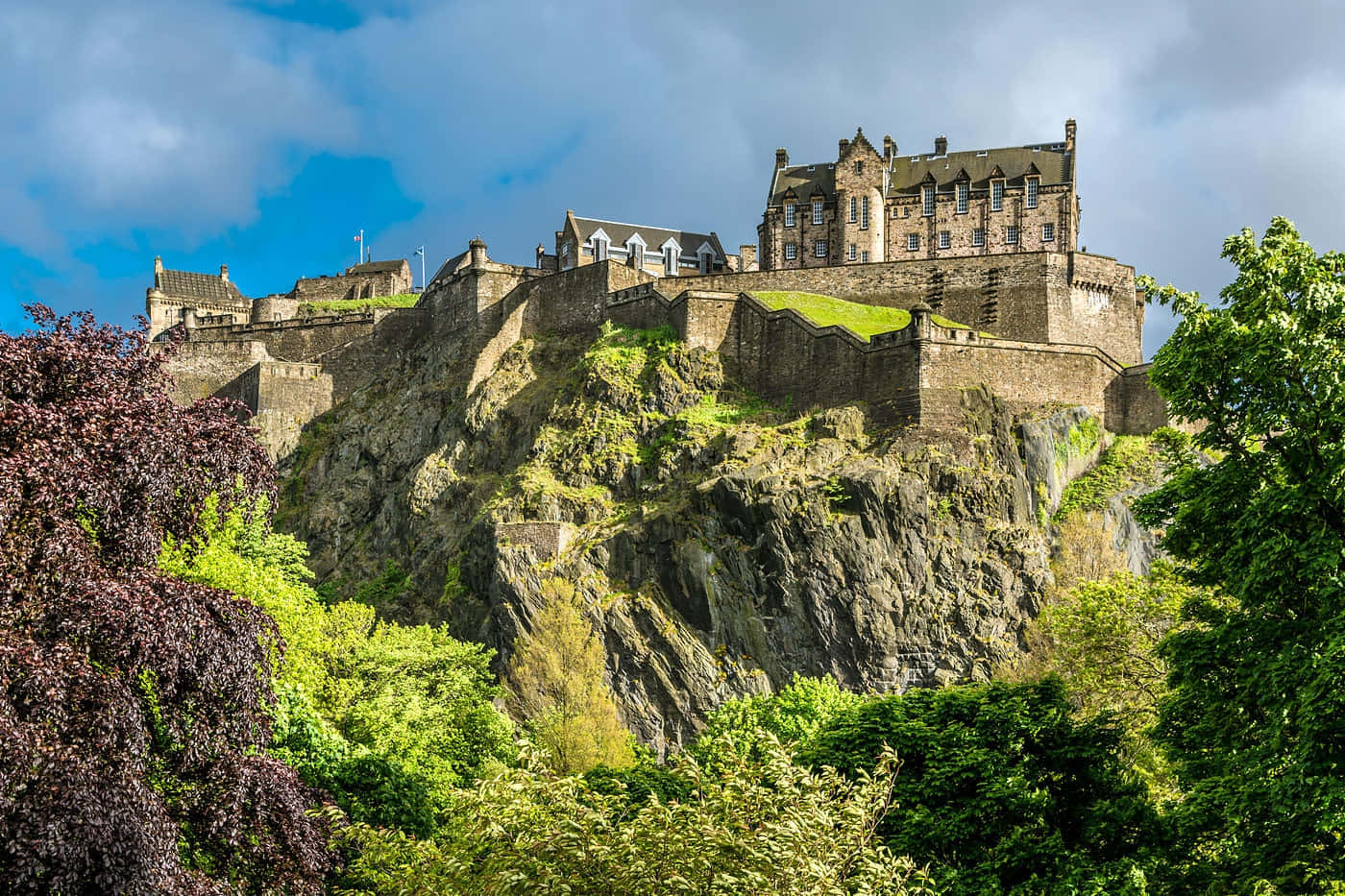 The Majestic Edinburgh Castle Perched Atop The Rocky Crags At Dusk Wallpaper