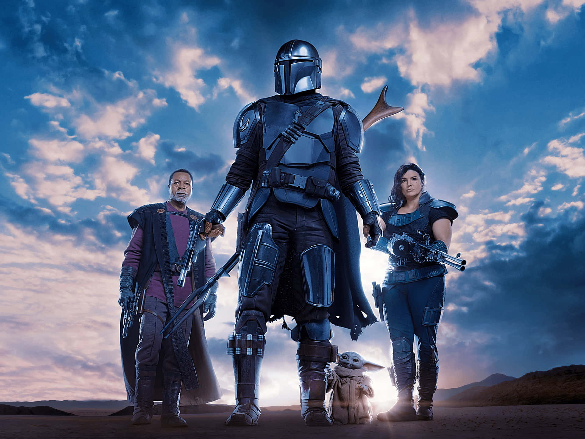 Caption: The Mandalorian walks into action with the Child by his side in a remote desert landscape.