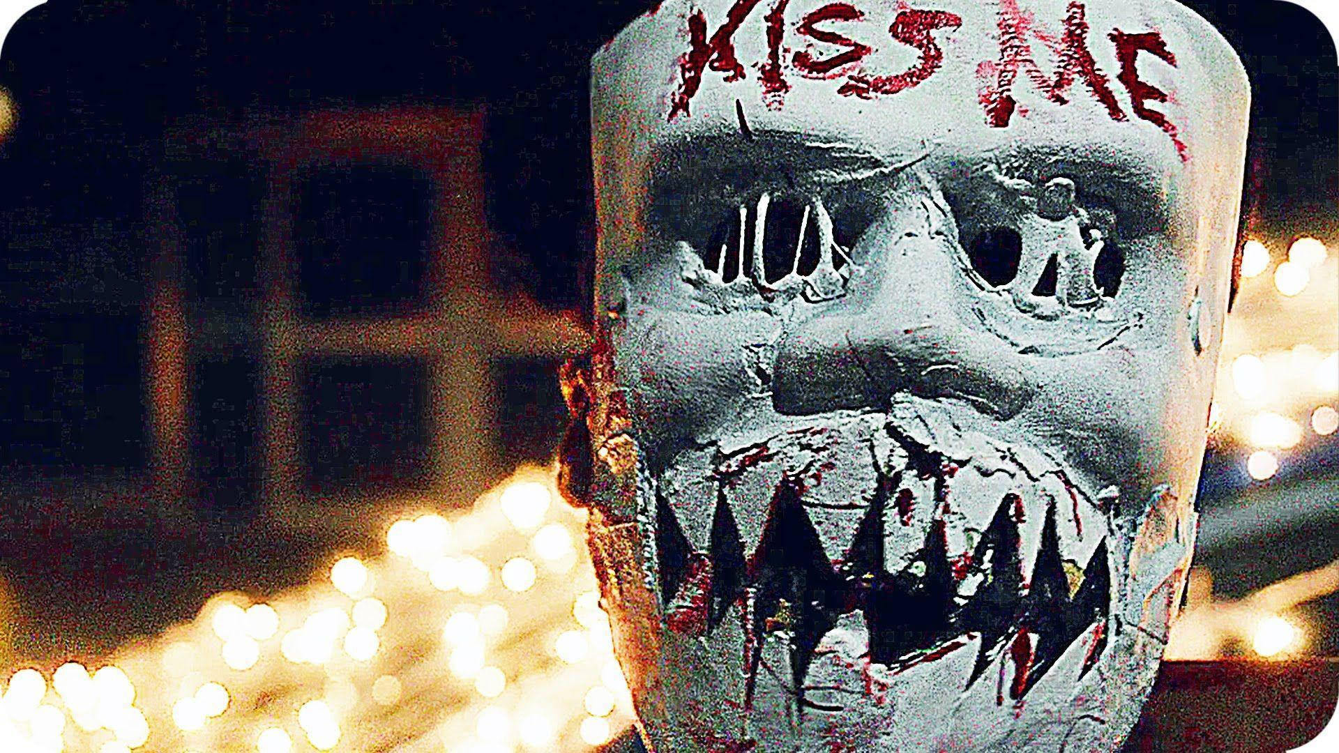 Intense Moment from The Purge Showcasing the Infamous 'Kiss Me' Mask Wallpaper