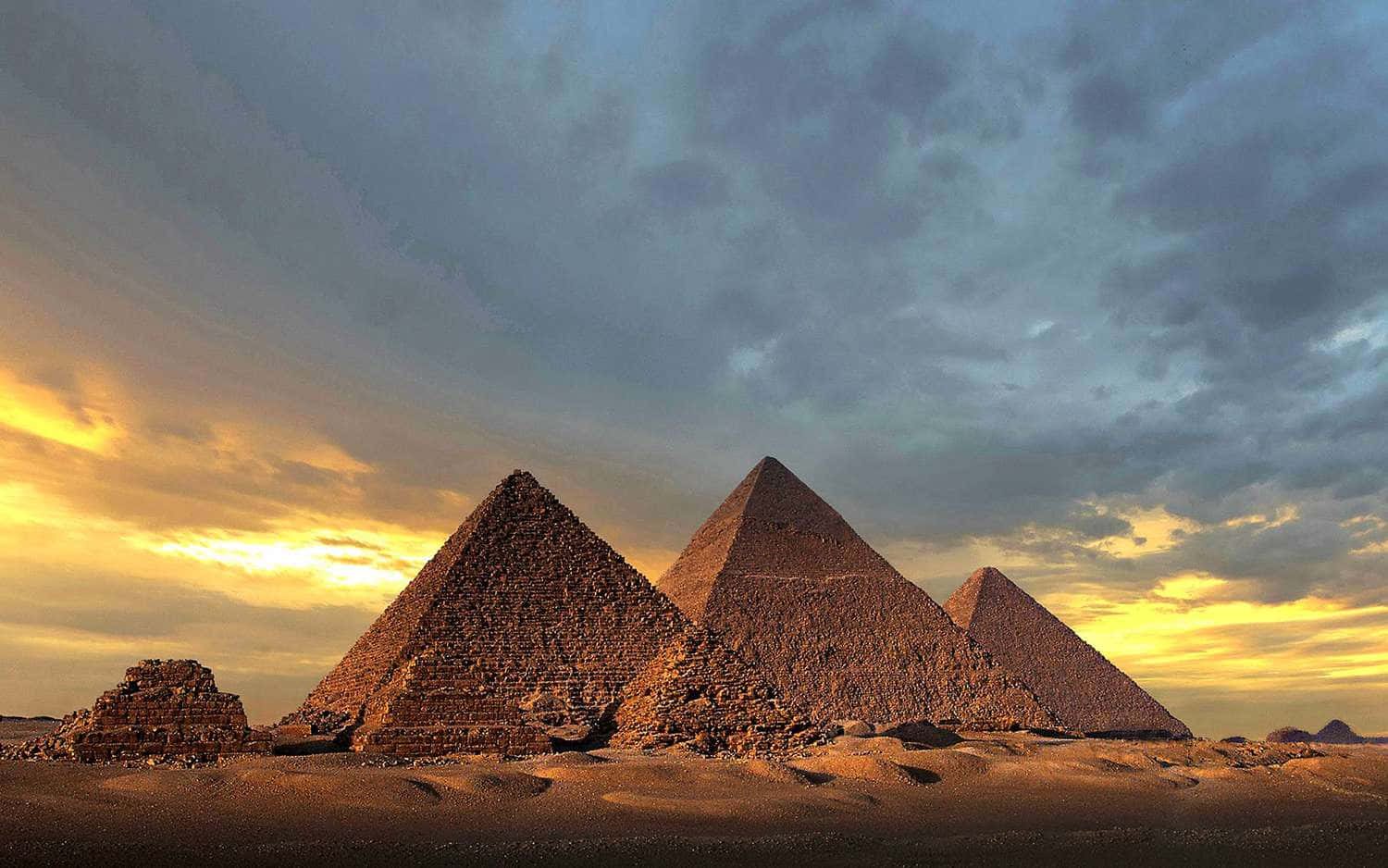 The Pyramids Of Giza Shadowed By An Overcast Sky Wallpaper