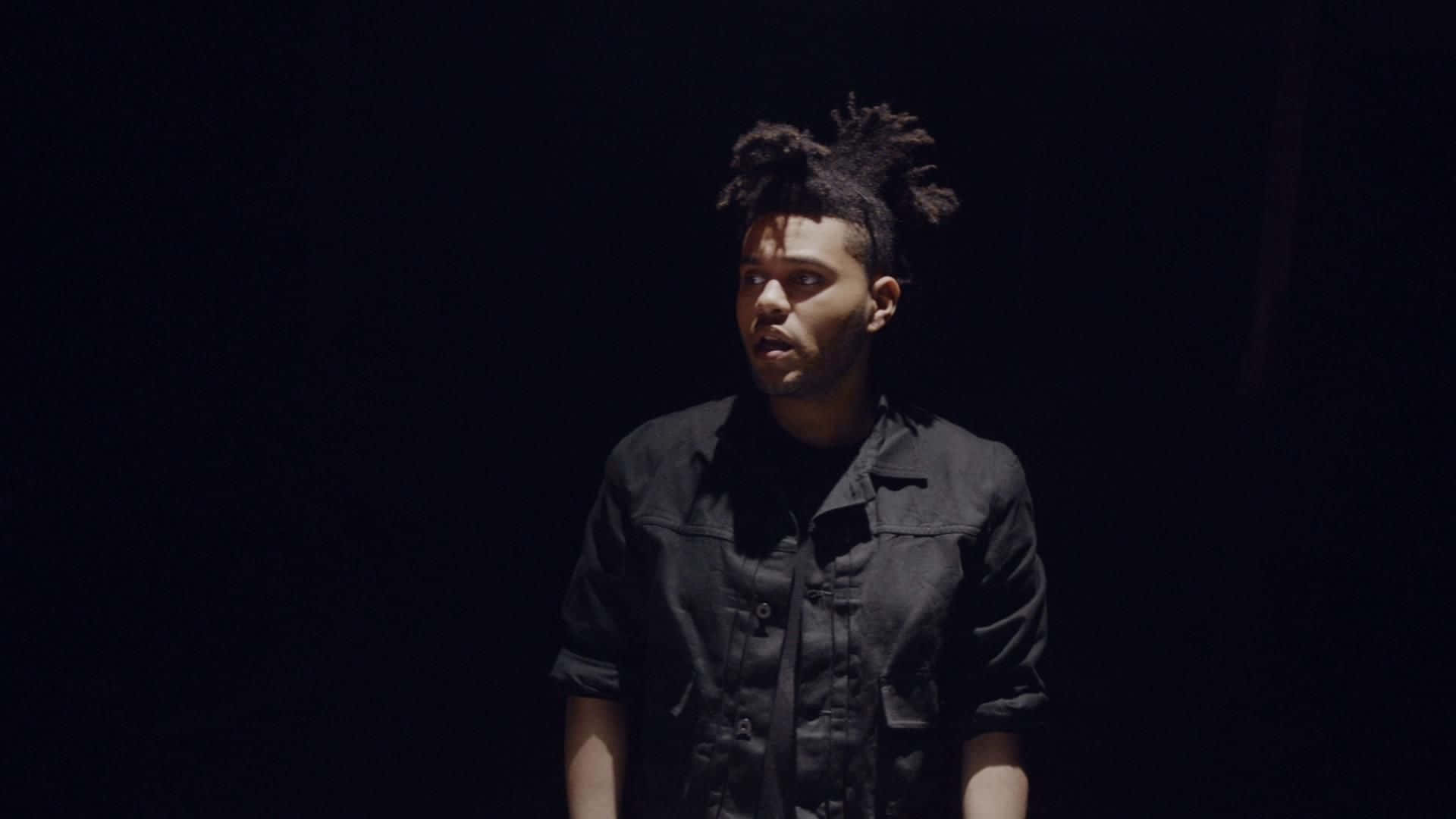 The Weeknd performing under the spotlight