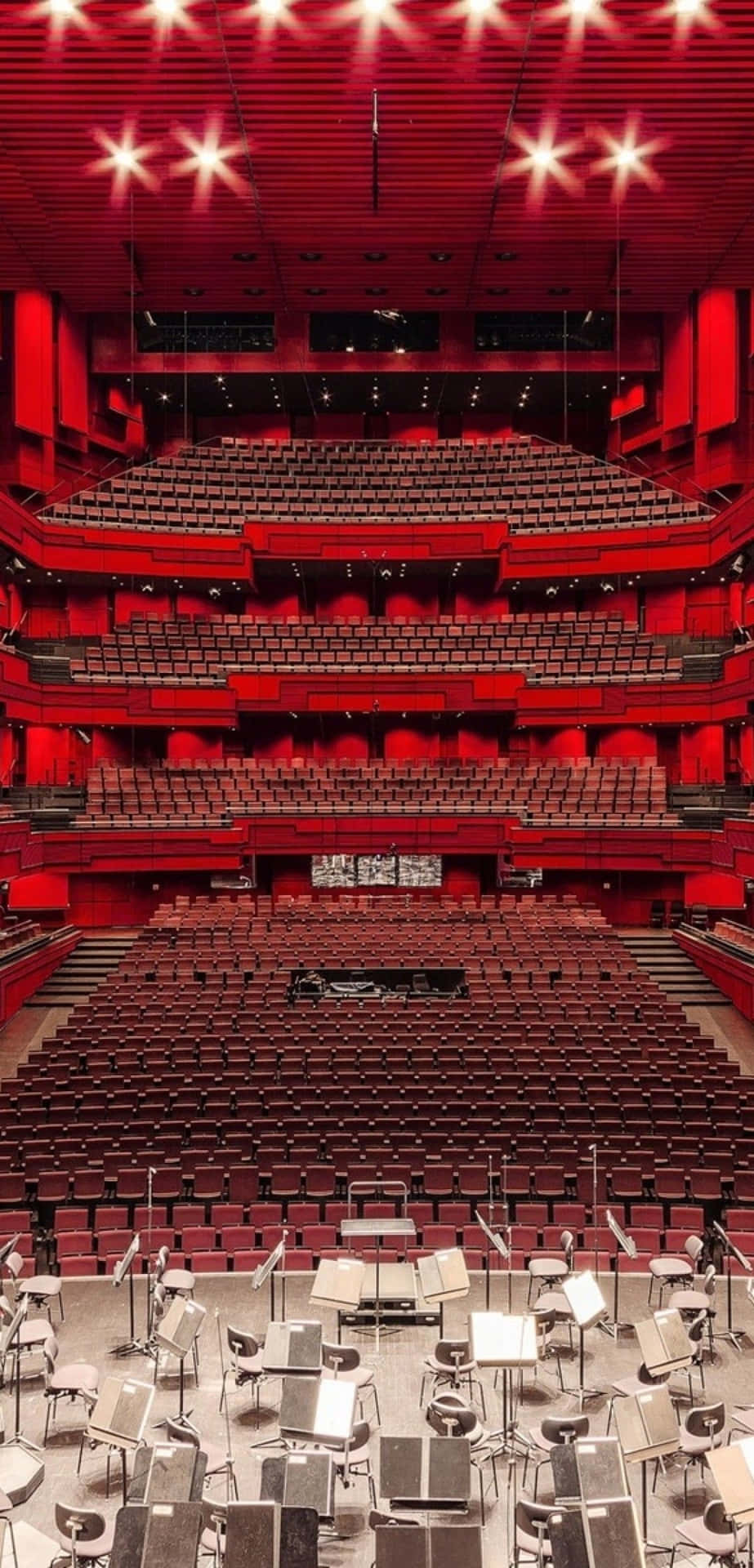 A Large Auditorium With Red Seats And Chairs