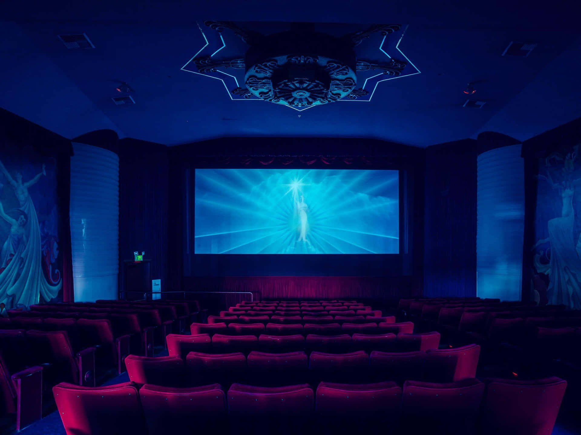 A Cinema With A Screen And Red Chairs