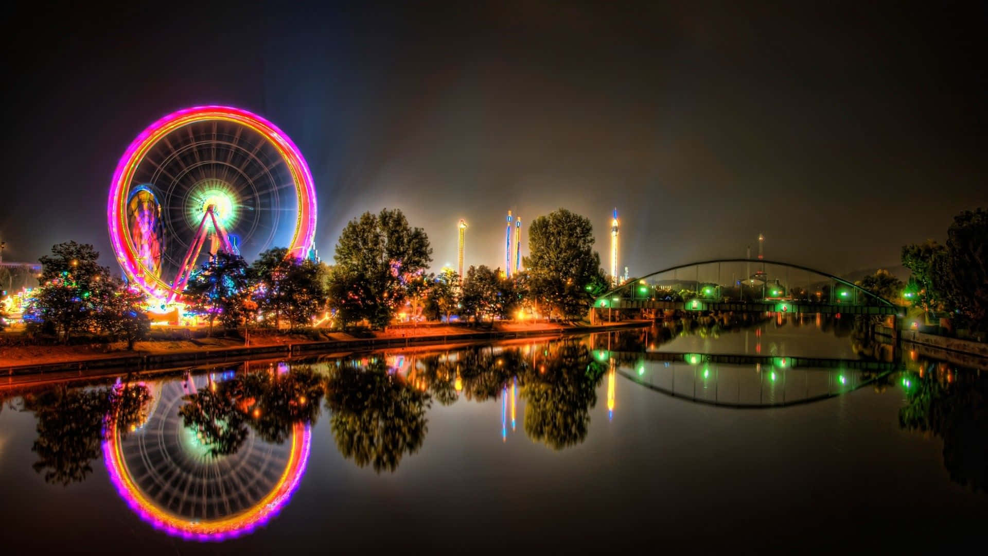 Ferris Wheel And Lights Reflect In The Water