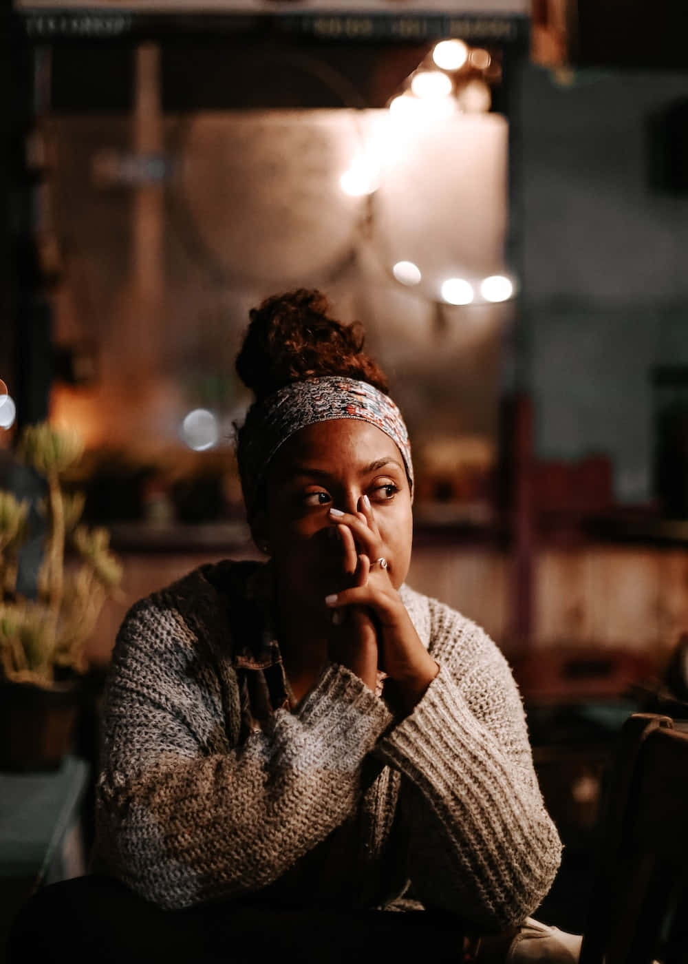 A Woman Sitting At A Table At Night