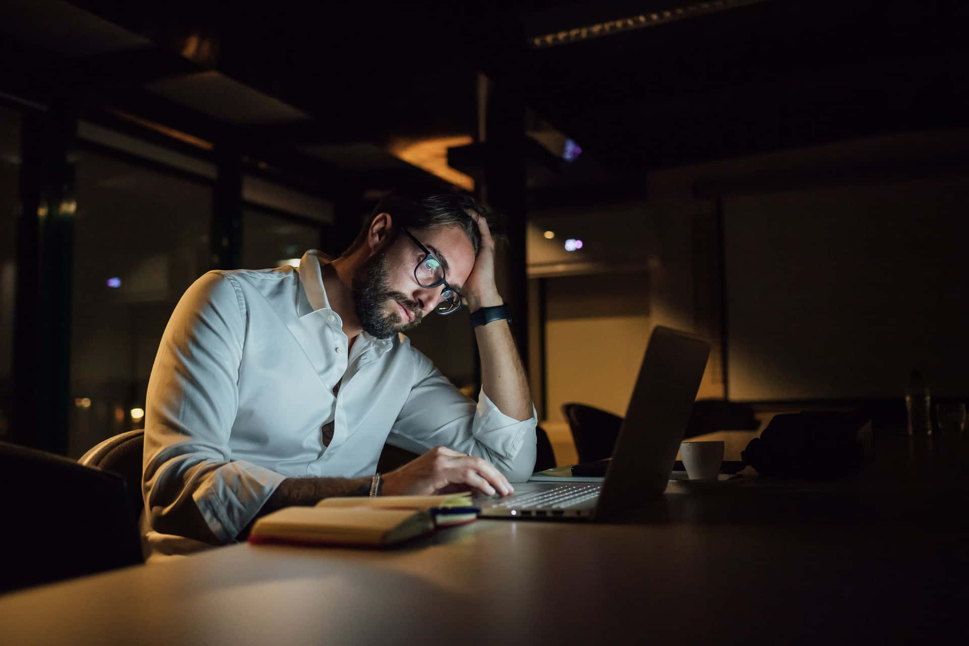 Man Working On Laptop At Night In Office