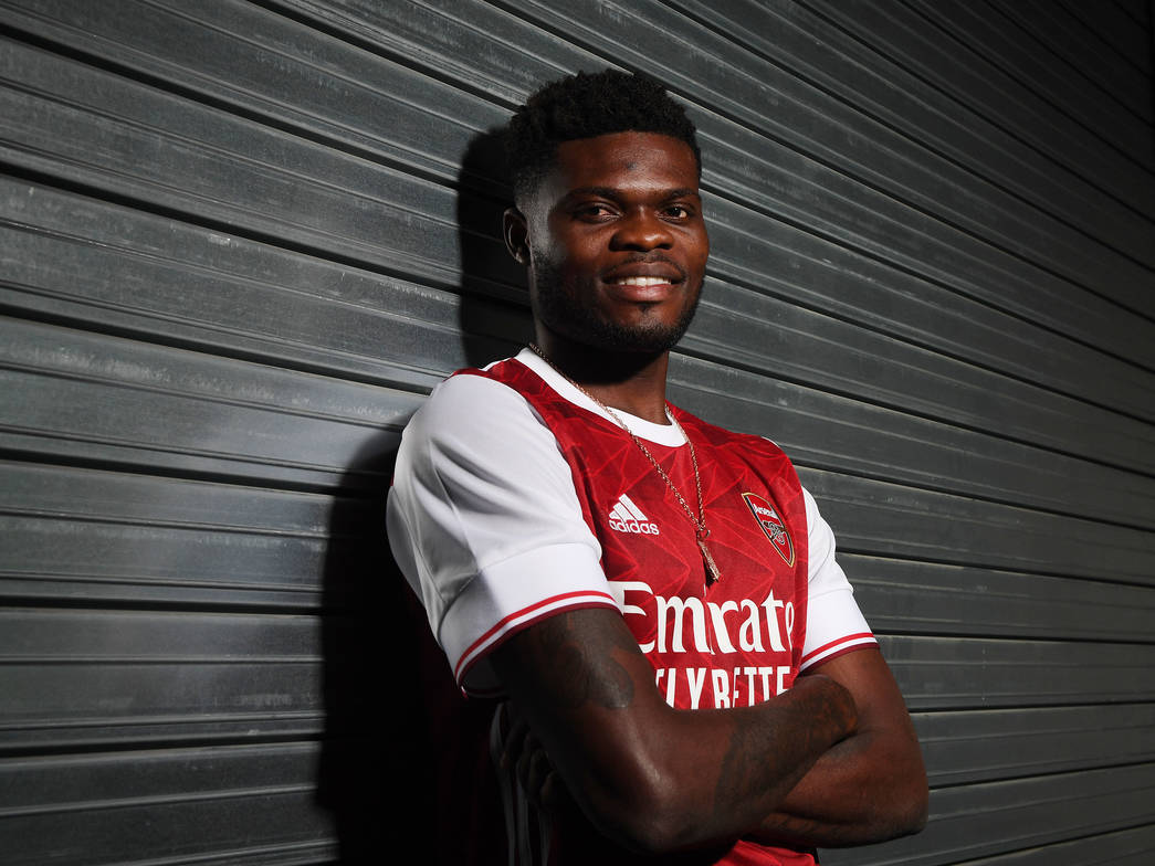 Thomas Partey Leaning Against A Metal Shutter Wallpaper