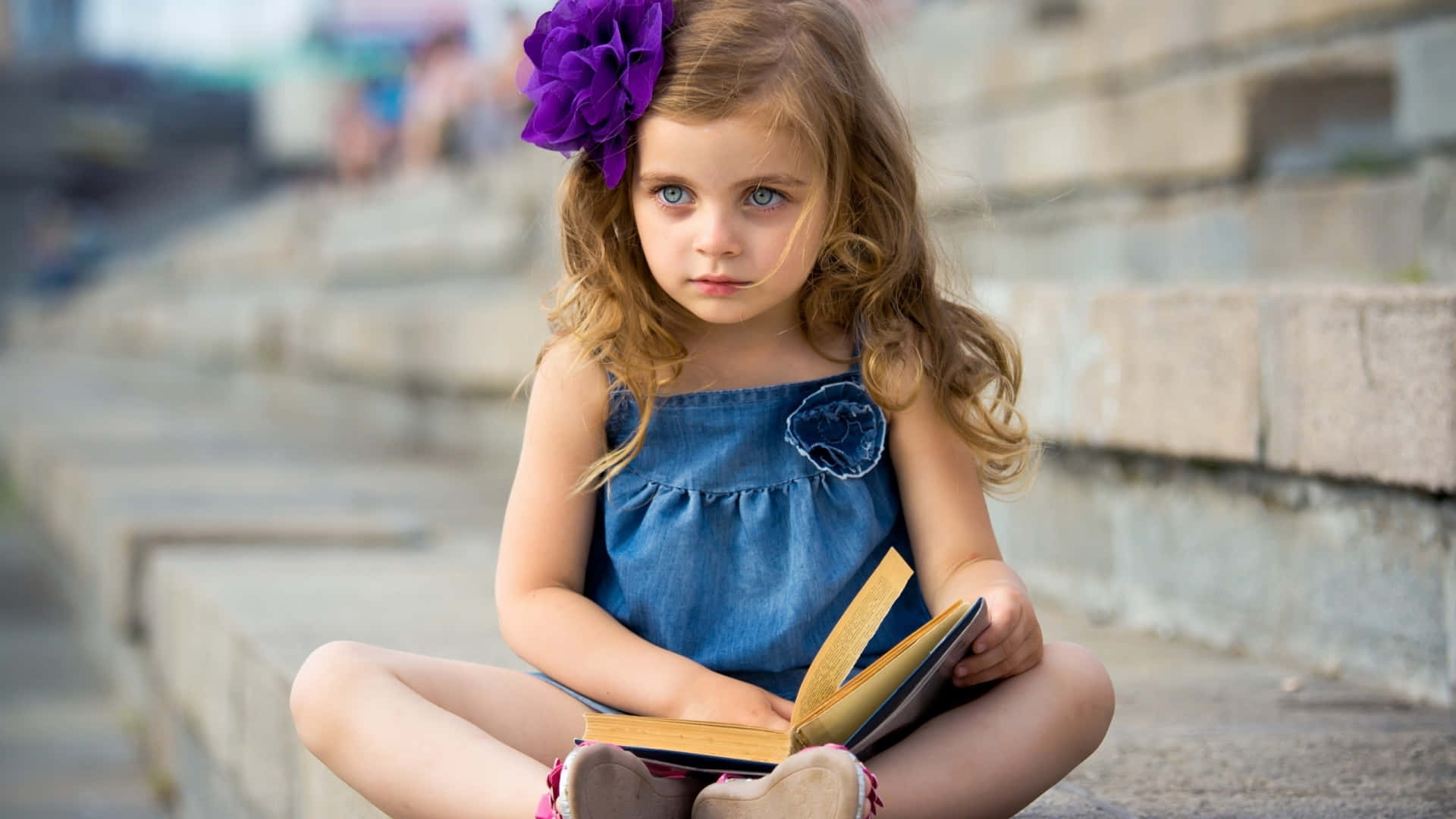 Thoughtful Little Girlwith Book Wallpaper
