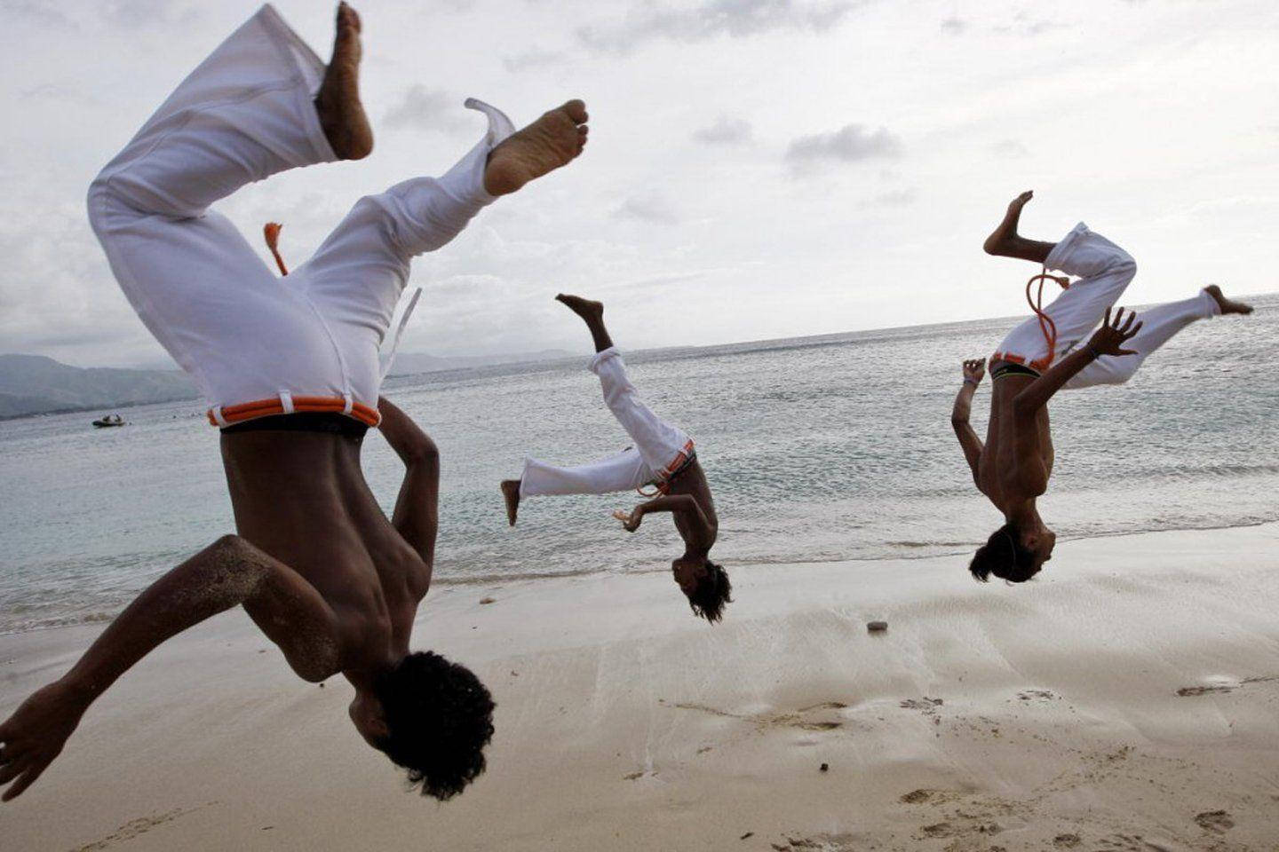 Tre Capoeira-kæmpere knækker en kødelusser. Wallpaper