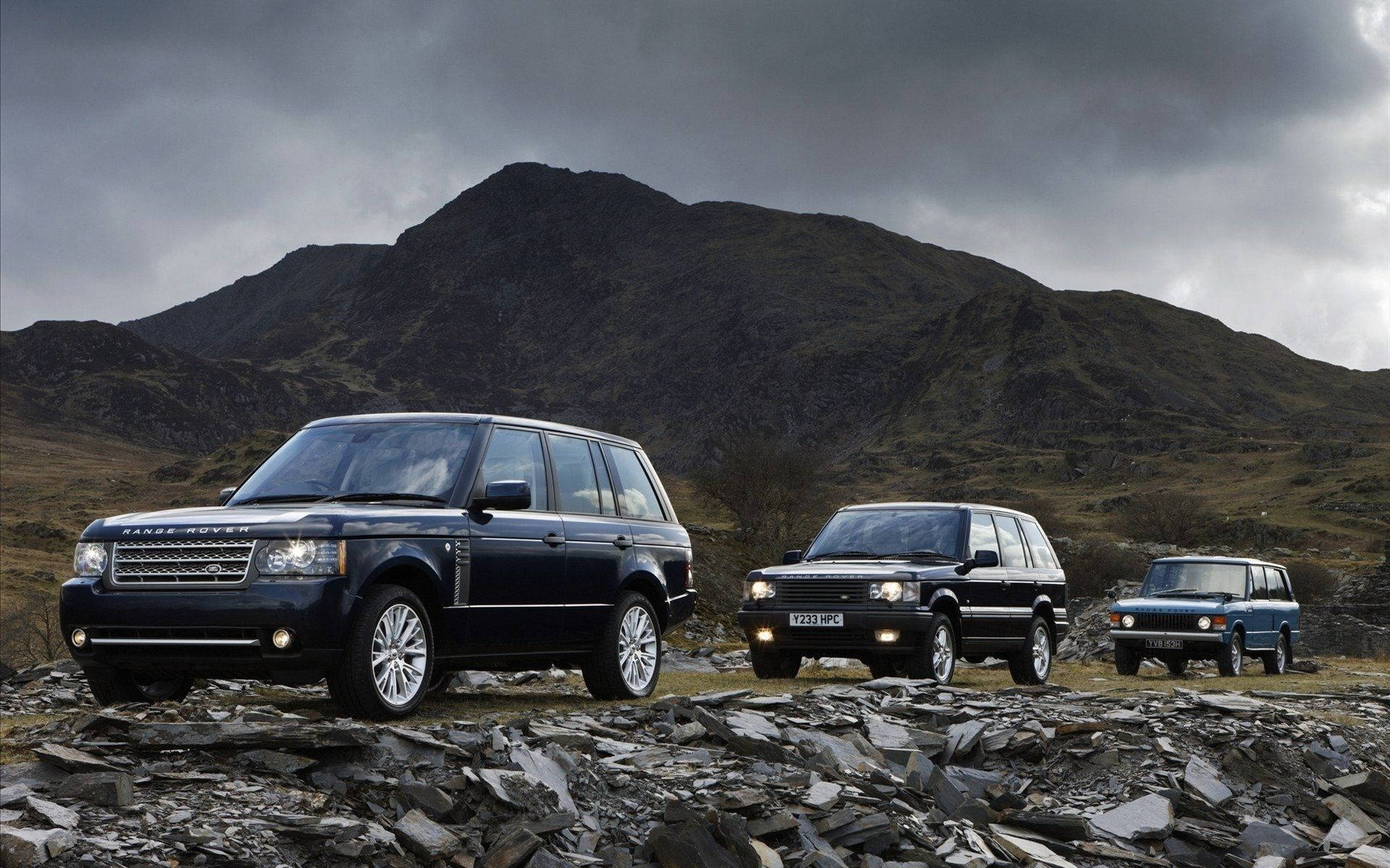 Three Land Rover Cars in a Variety of Colors Wallpaper