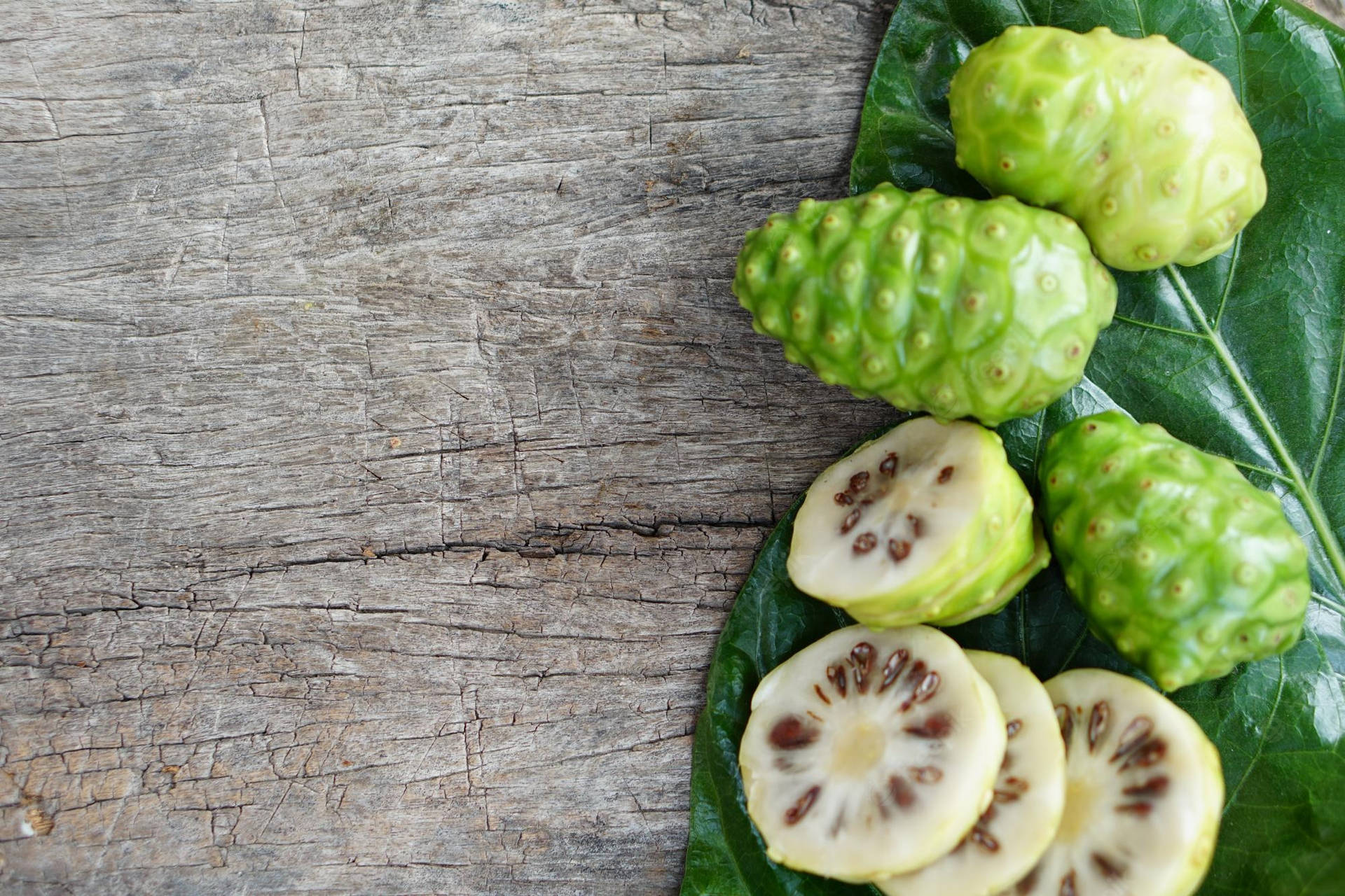 Three Whole Noni Fruits And Slices Wallpaper