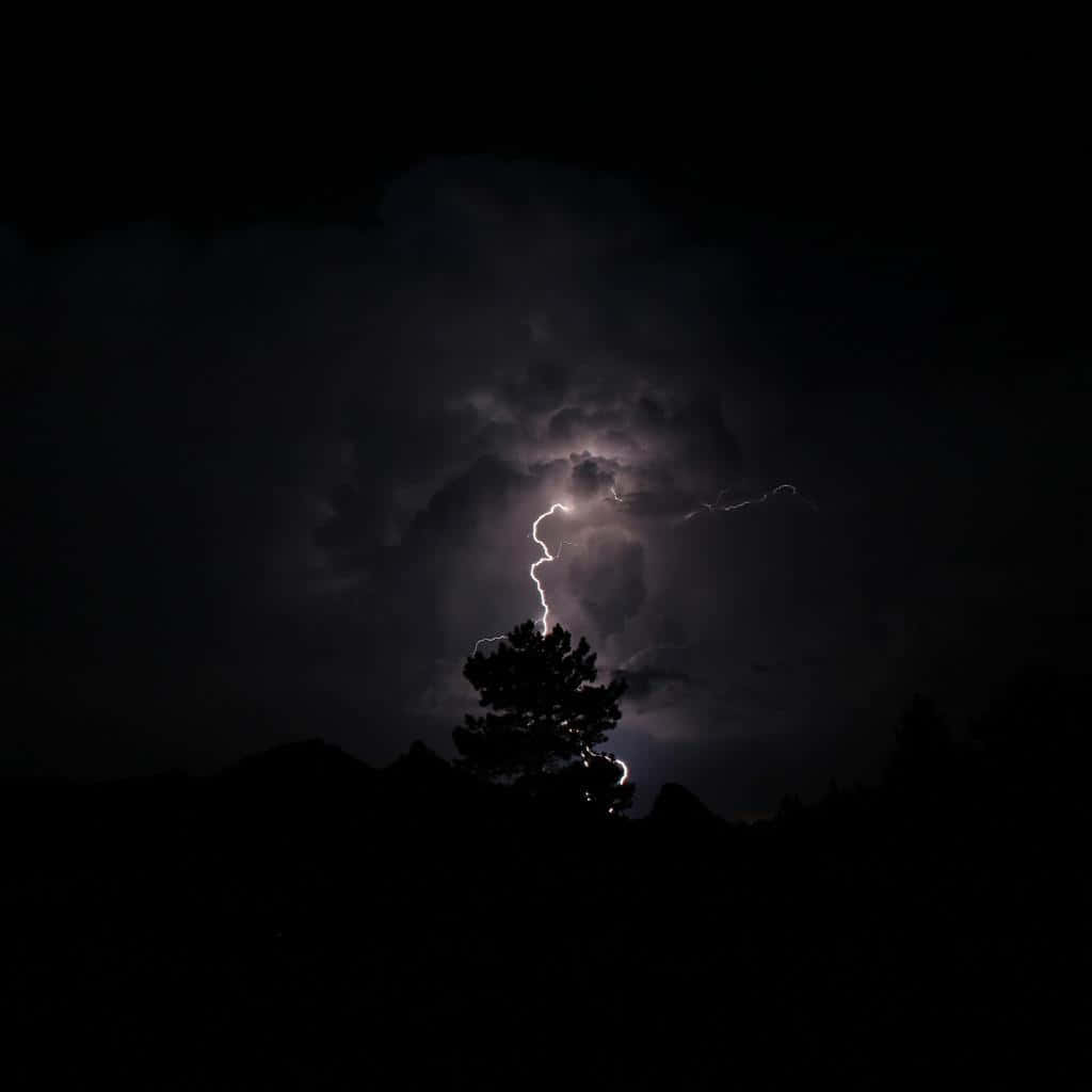 A fiery night sky beneath a thunderstorm brewing