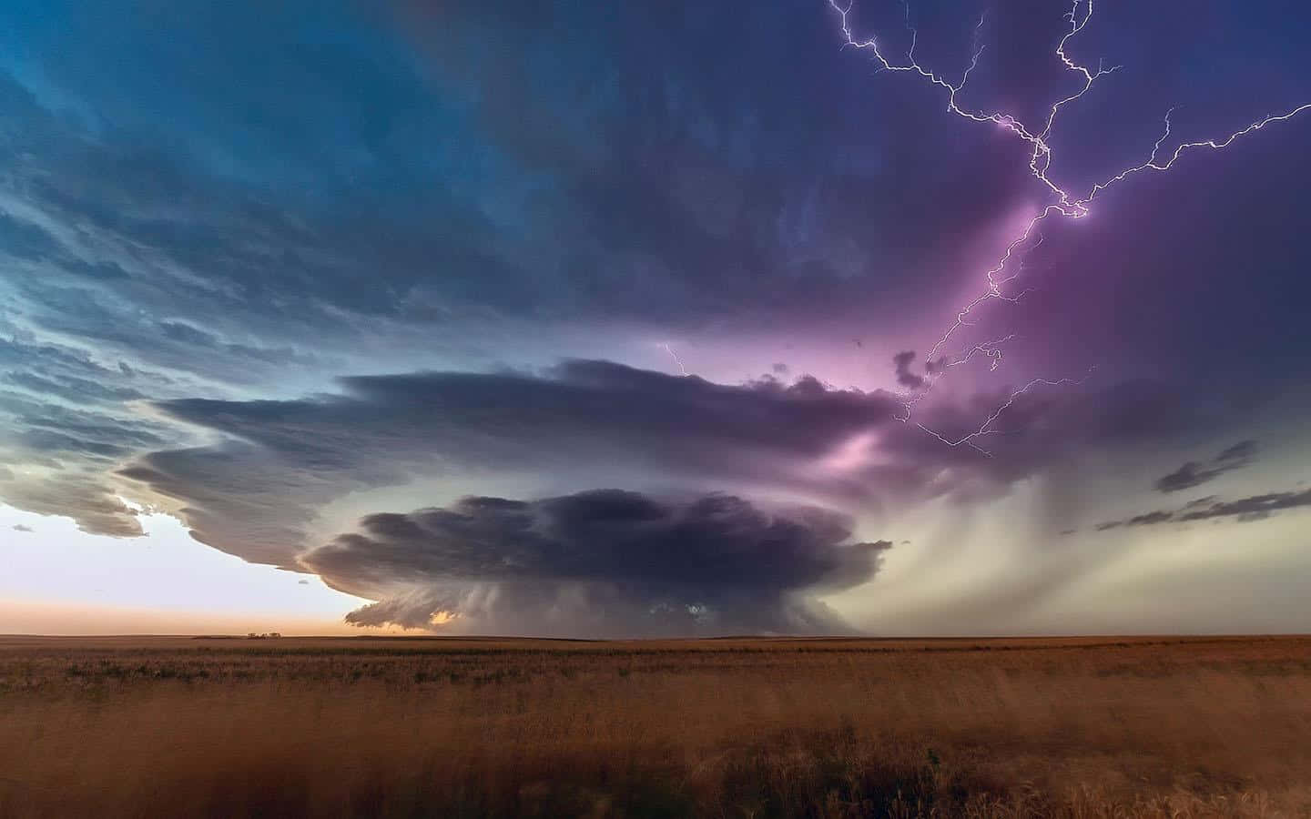 Download Majestic Thunderstorm Over a Tranquil Landscape | Wallpapers.com