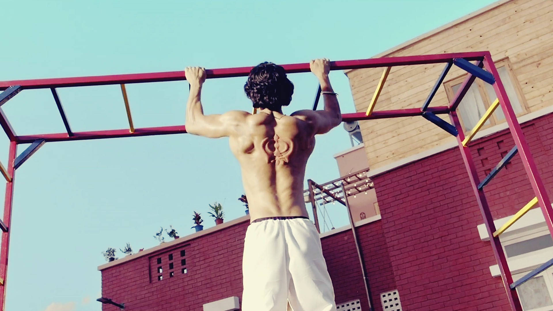 Download Tiger Shroff Body While Doing Pull Ups Wallpaper 