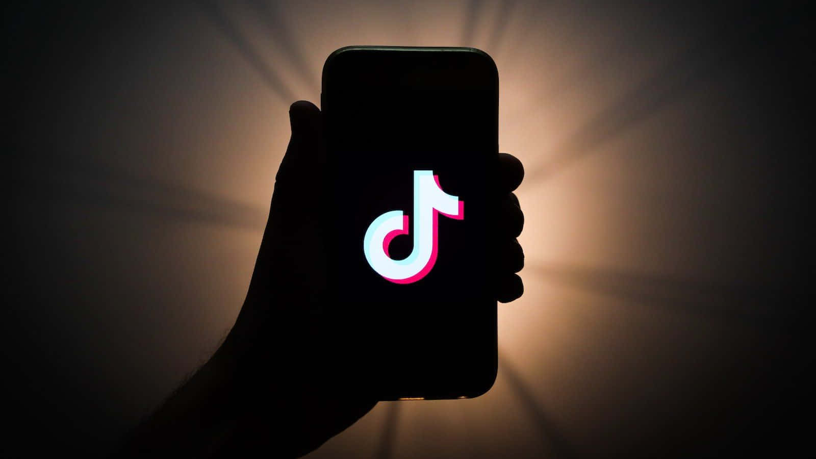 a person holding up a phone with the tiktok logo on it