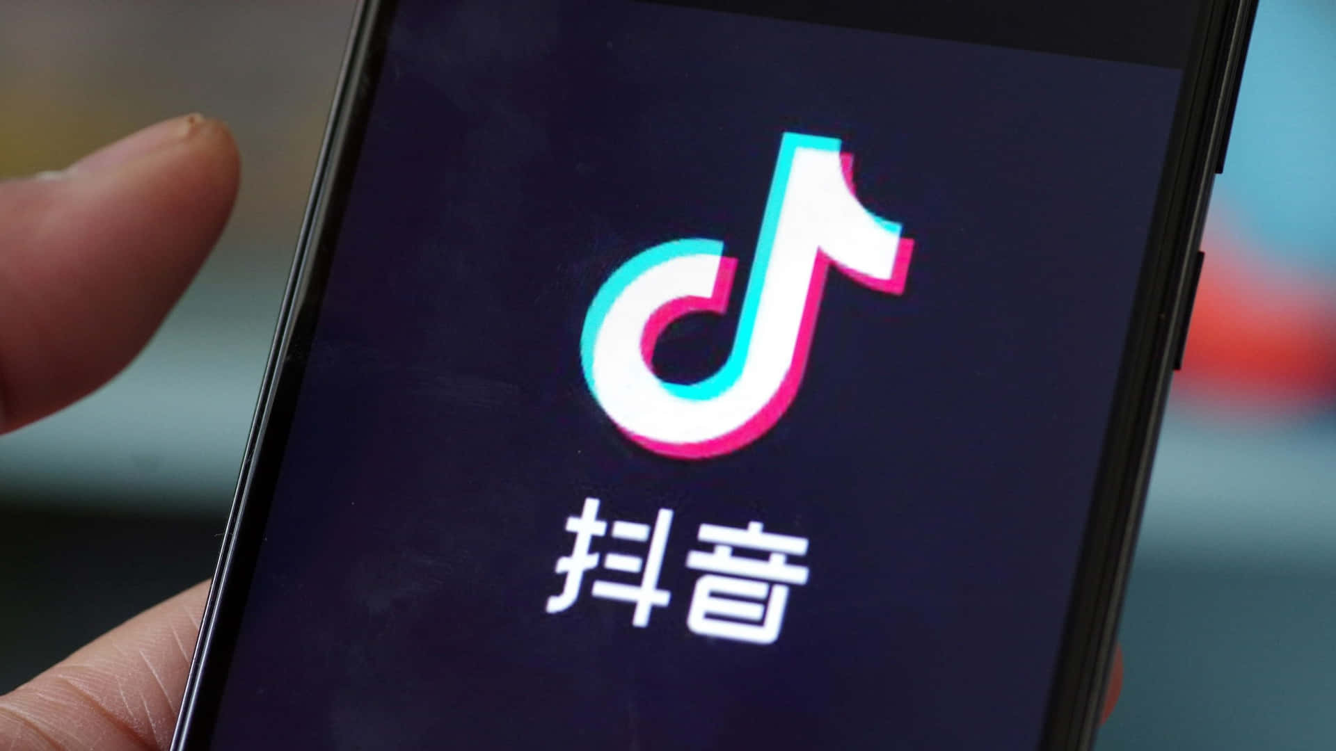 a person is holding up a phone with the tiktok logo on it
