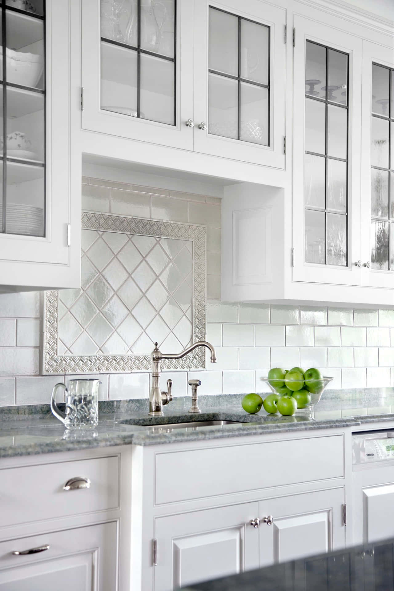 A White Kitchen With A Sink And Counter Top