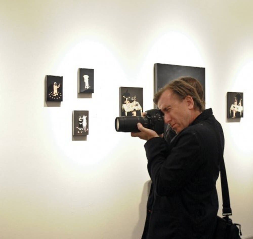 Tim Roth With Camera In An Art Museum Background