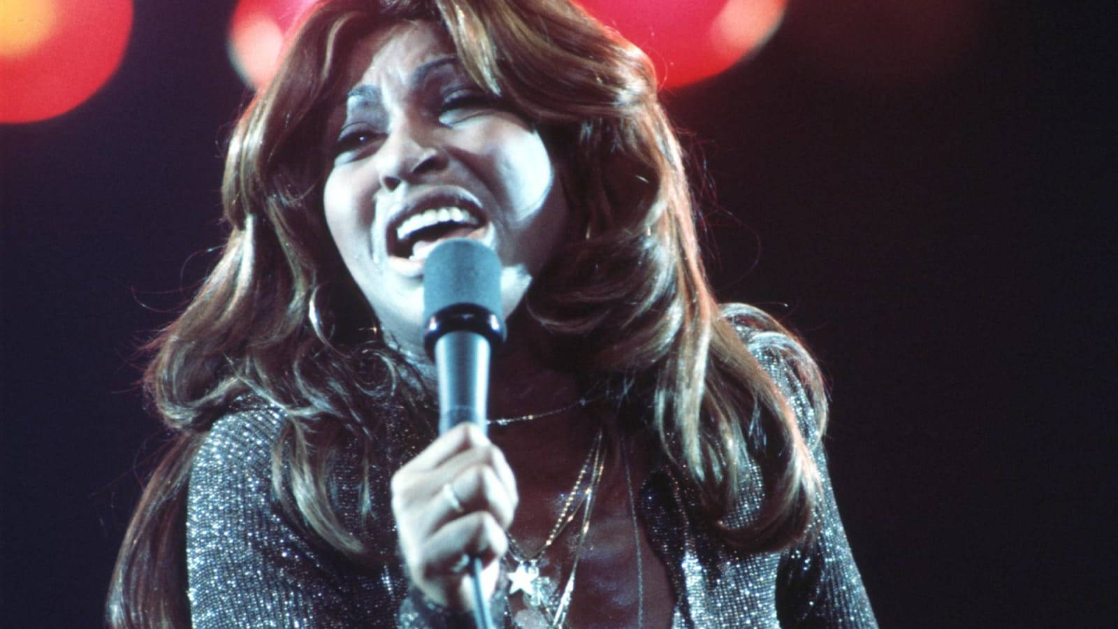 Tina Turner Live Præstation 1976 skaber et dramatisk effektbaggrund. Wallpaper
