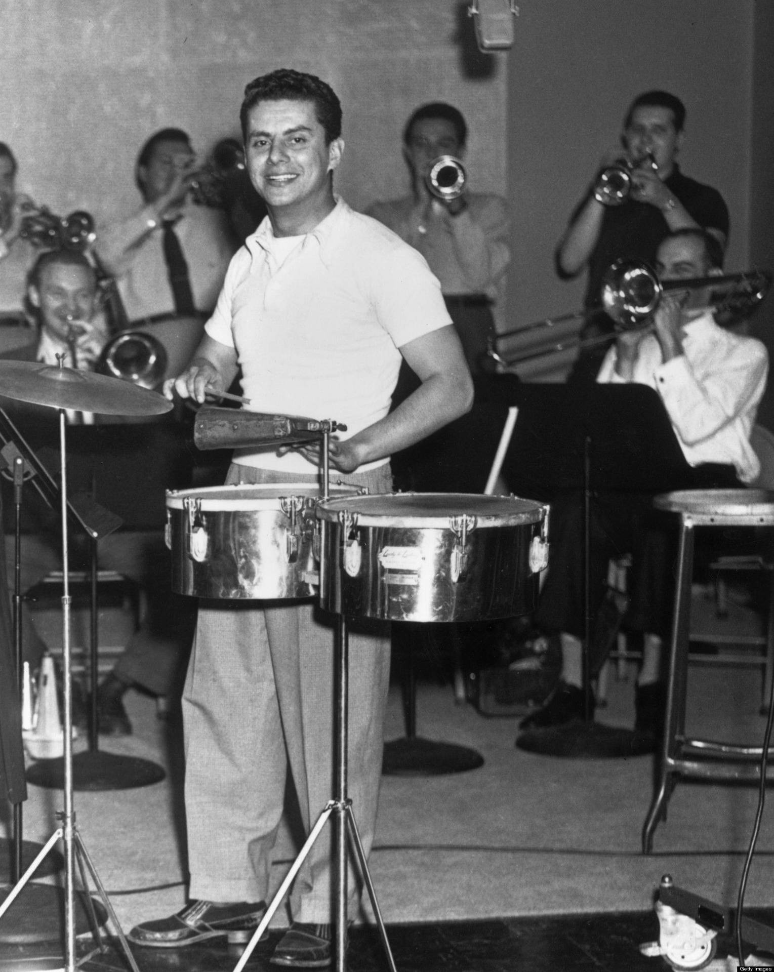 Tito Puente leading his vibrant band in a live performance. Wallpaper