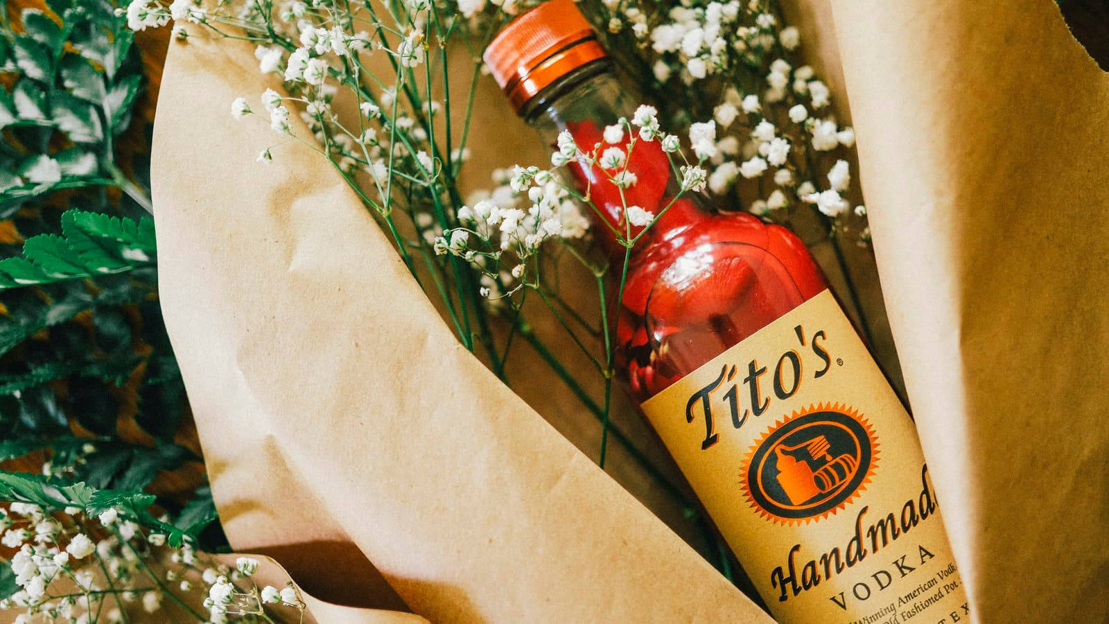 Titos Vodka With Small White Flowers Wallpaper