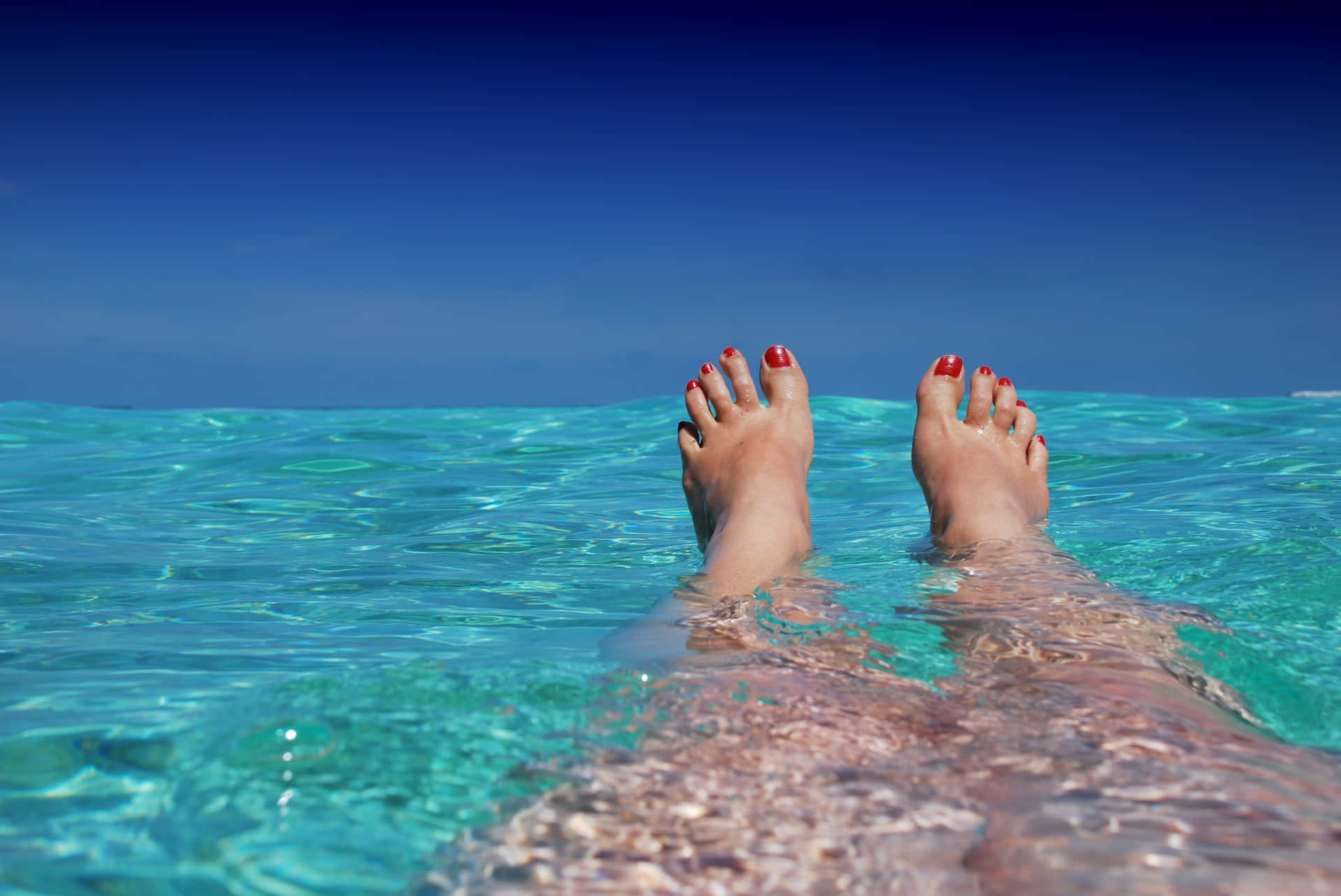 Tranquil Moment: Feet Soaking in Crystal Clear Water Wallpaper