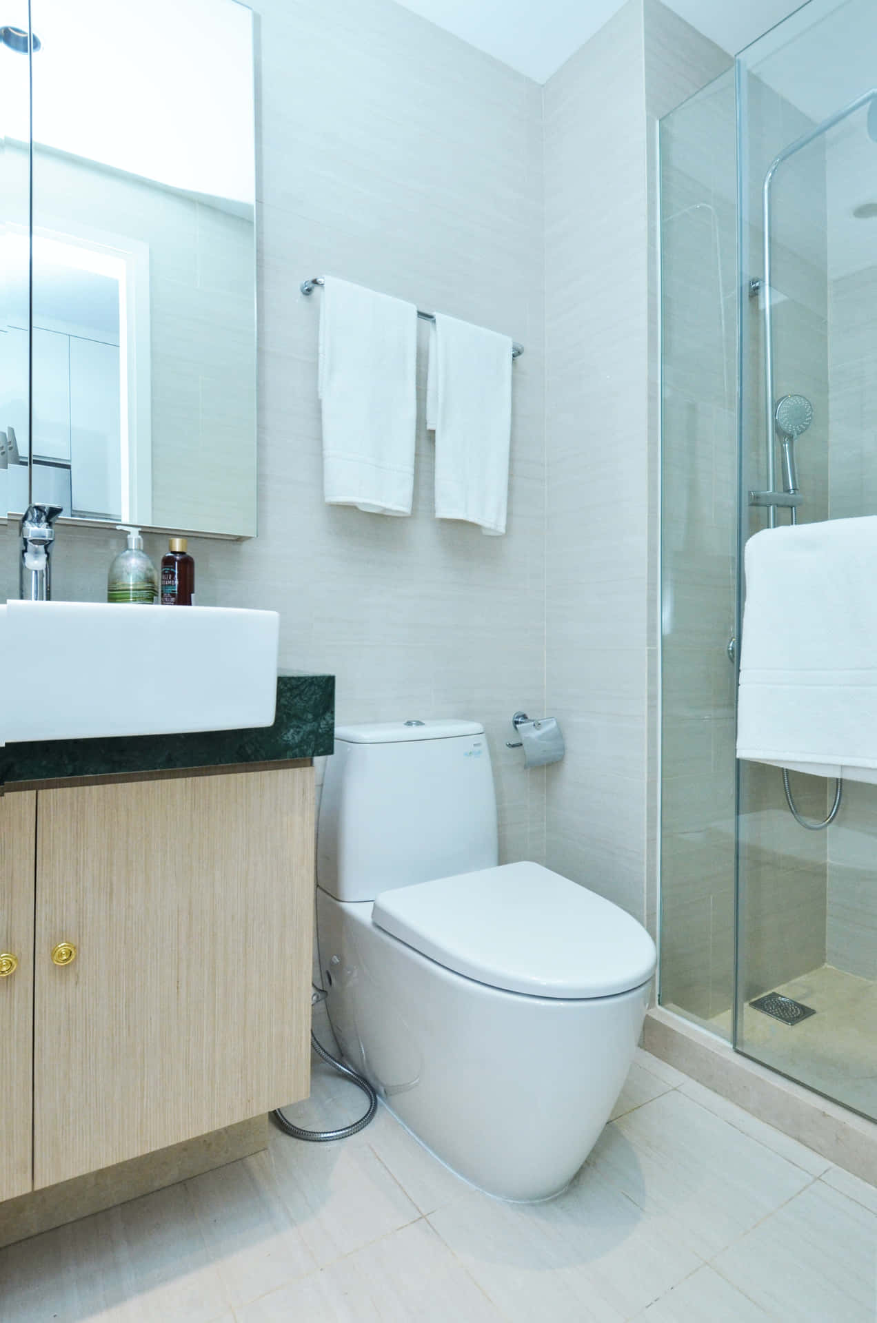 Enmoderne Badeværelse Med Stilfulde Glasvaske, Keramiske Fliser Og En Fejlfri Toilet.