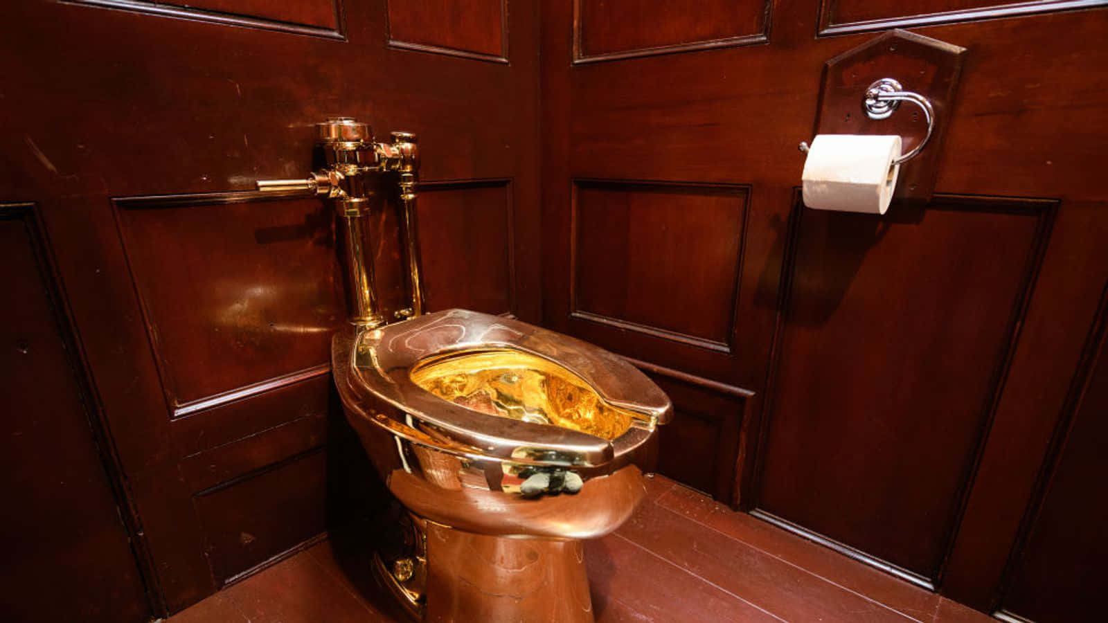 A Toilet With A Gold Seat In A Wooden Room