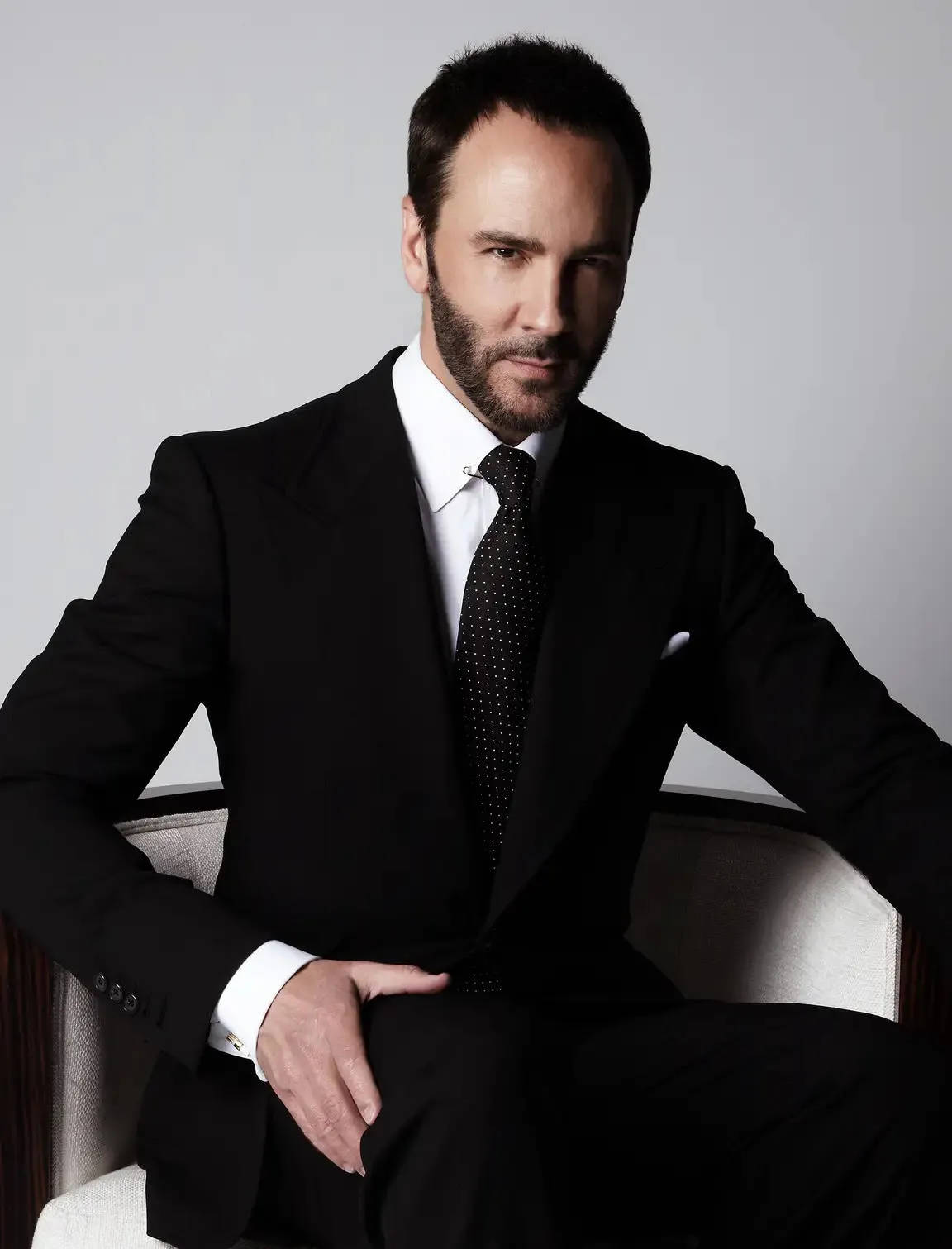 Tom Ford Posing On Chair Background
