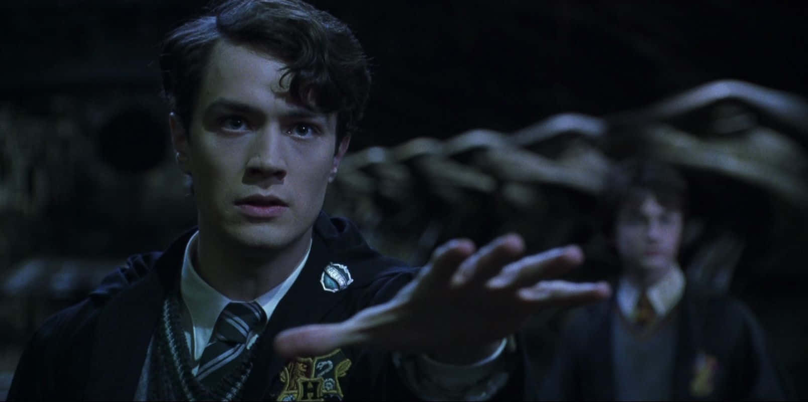A young Tom Riddle wielding a wand against a dark backdrop Wallpaper