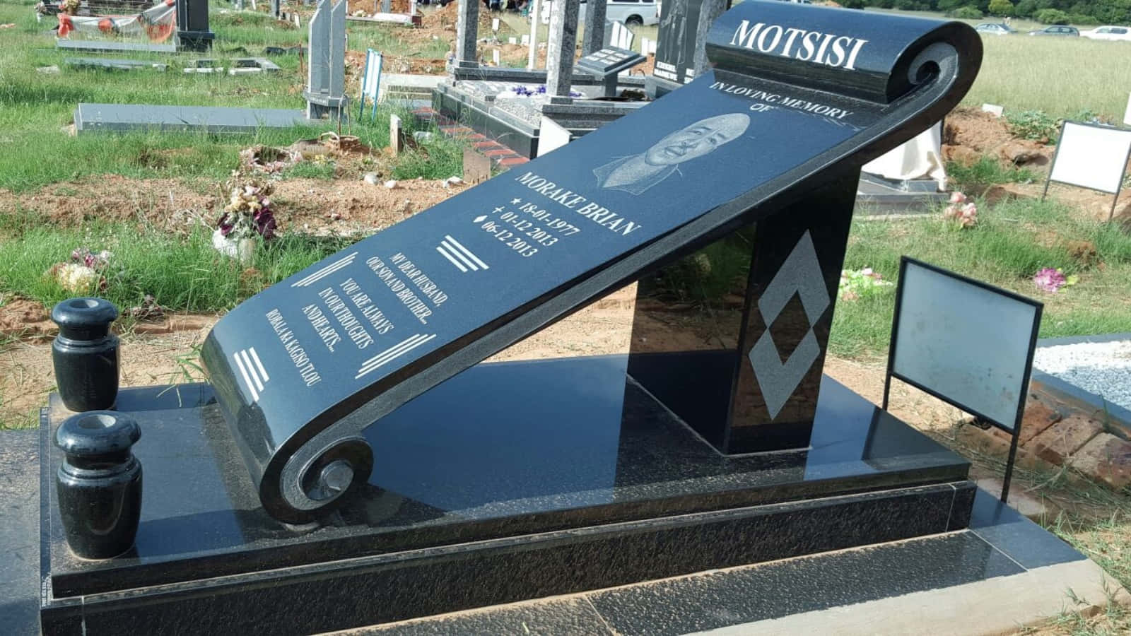 A Gravestone With A Black Book On It