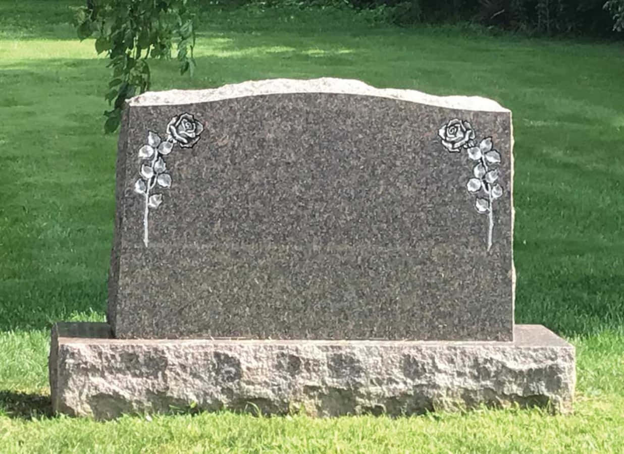 A Gravestone With A Flower On It