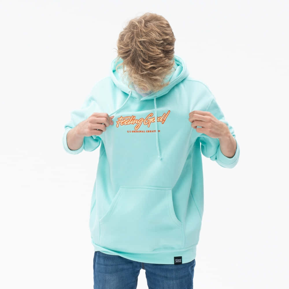A Young Man Wearing A Mint Green Hoodie With Orange Letters