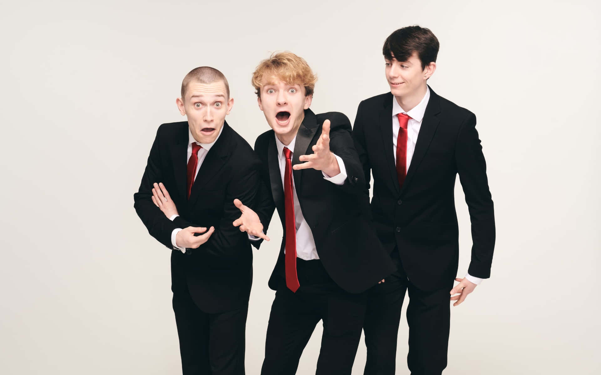 Three Young Men In Suits And Ties Posing