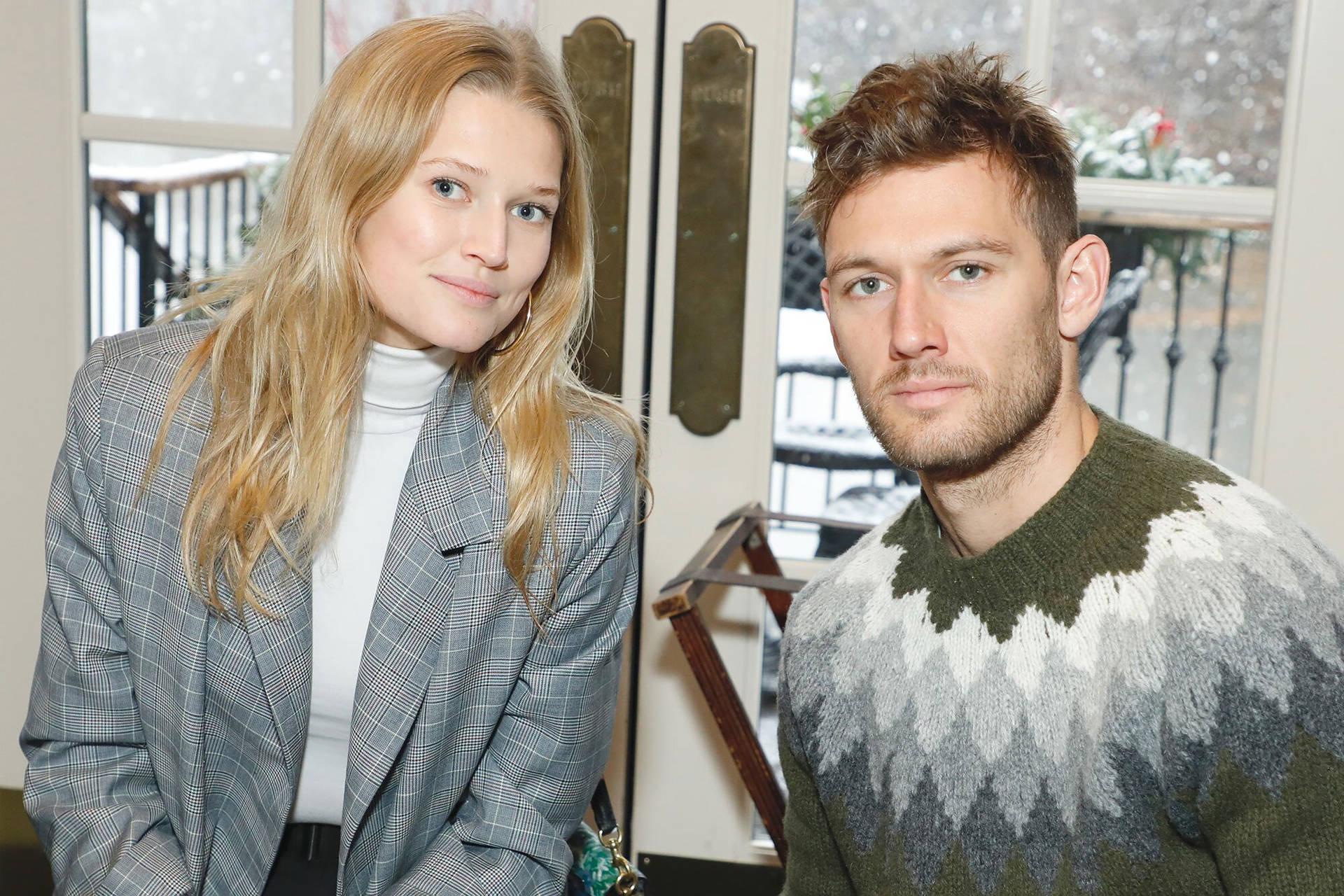 Toni Garrn and Alex Pettyfer posing together during an event Wallpaper
