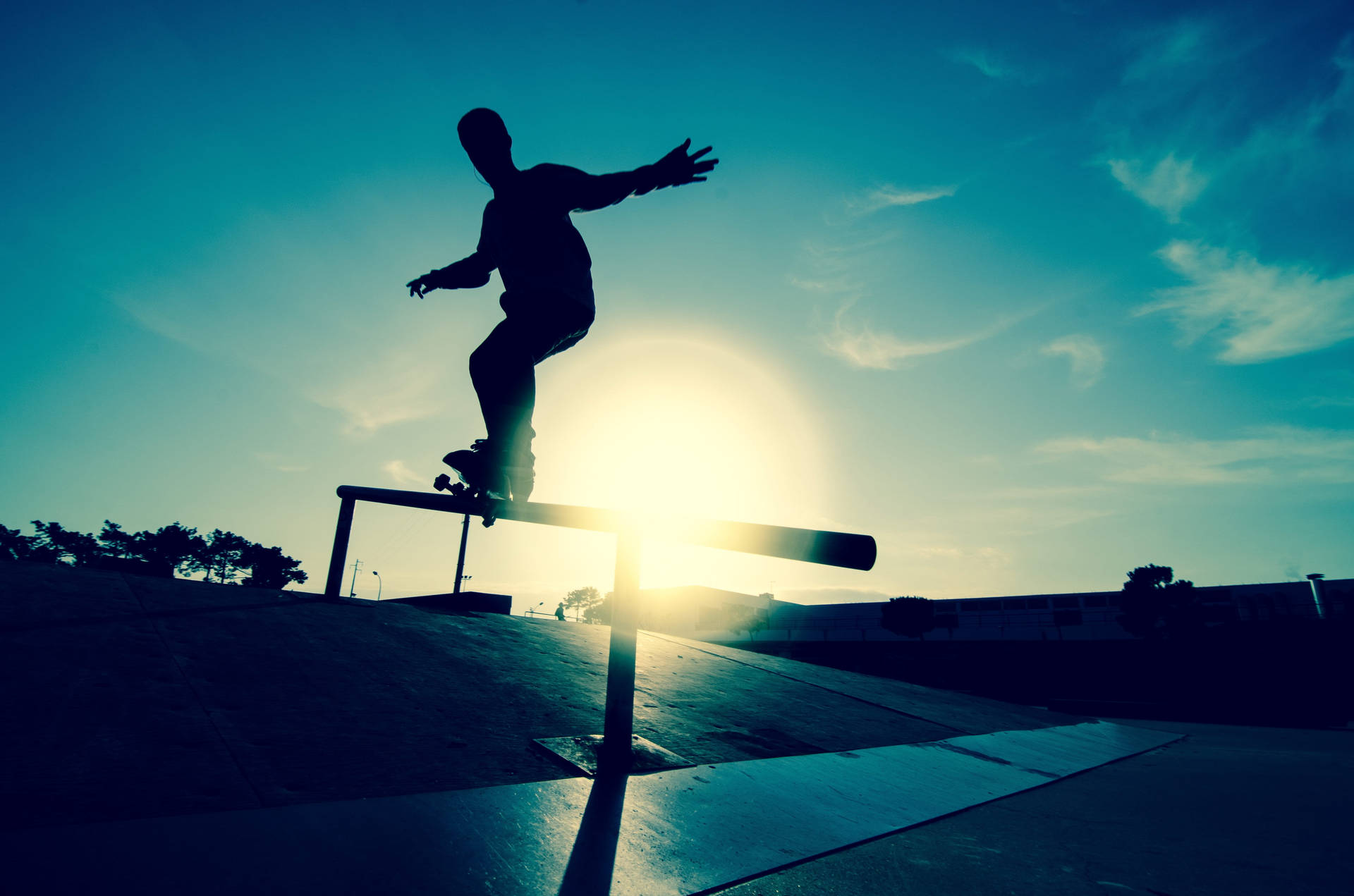 Tony Hawk Skater 3 Railing Silhouette Tapet: Se en skateboarder køre langs et rail med Tony Hawks skygge udtykt bagved. Wallpaper
