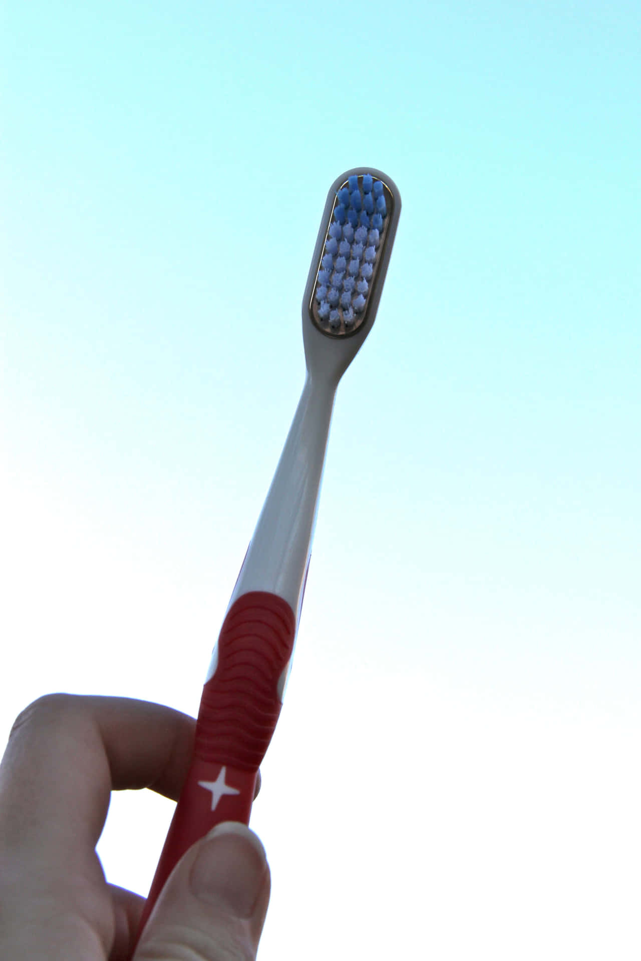 Toothbrush Held Against Sky Wallpaper