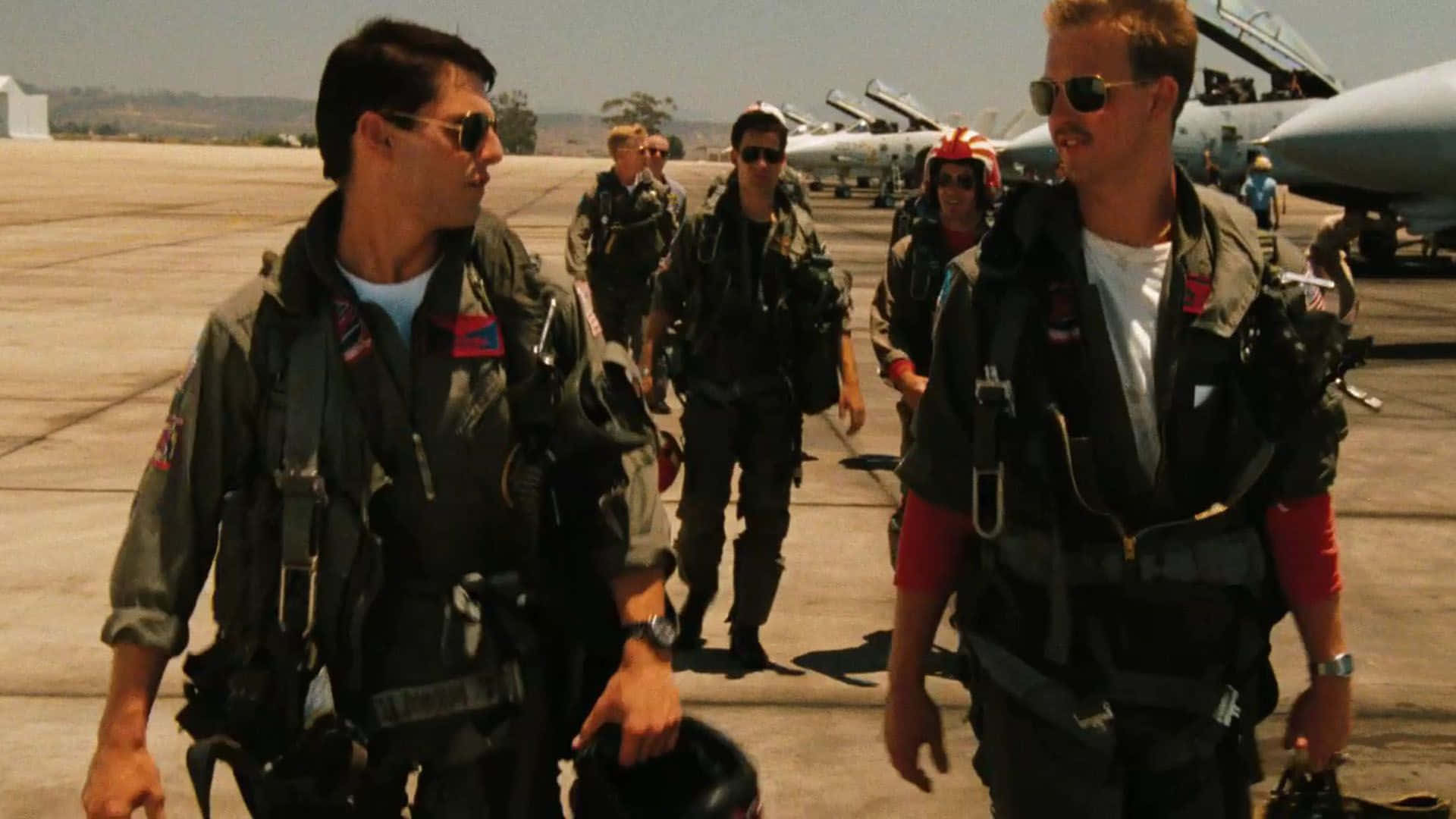 Top Gun Tom Cruise og Tom Skerritt rider F-14 jets over en klar blå himmel. Wallpaper