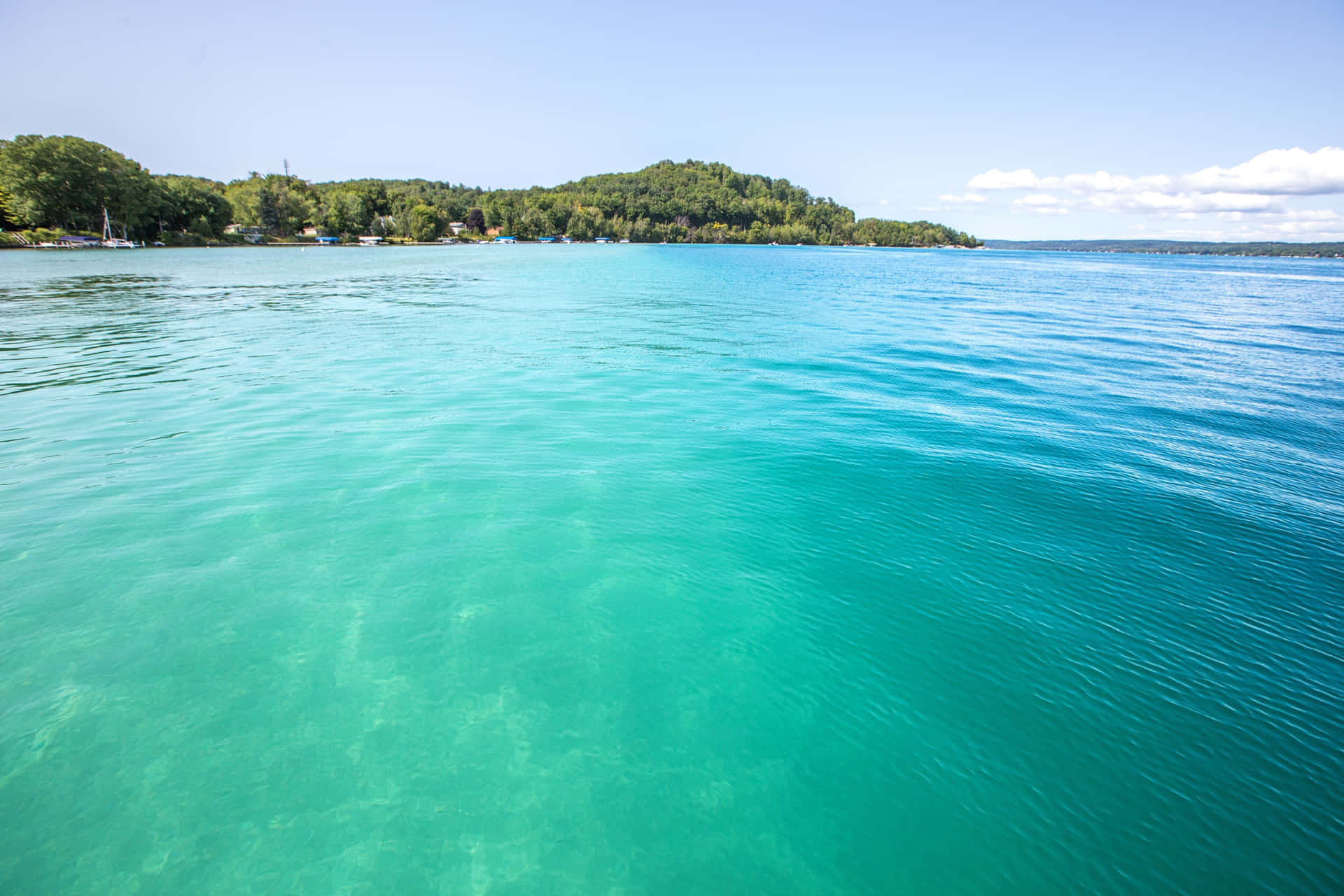 The breathtaking beauty of Torch Lake against a backdrop of lush greenery.