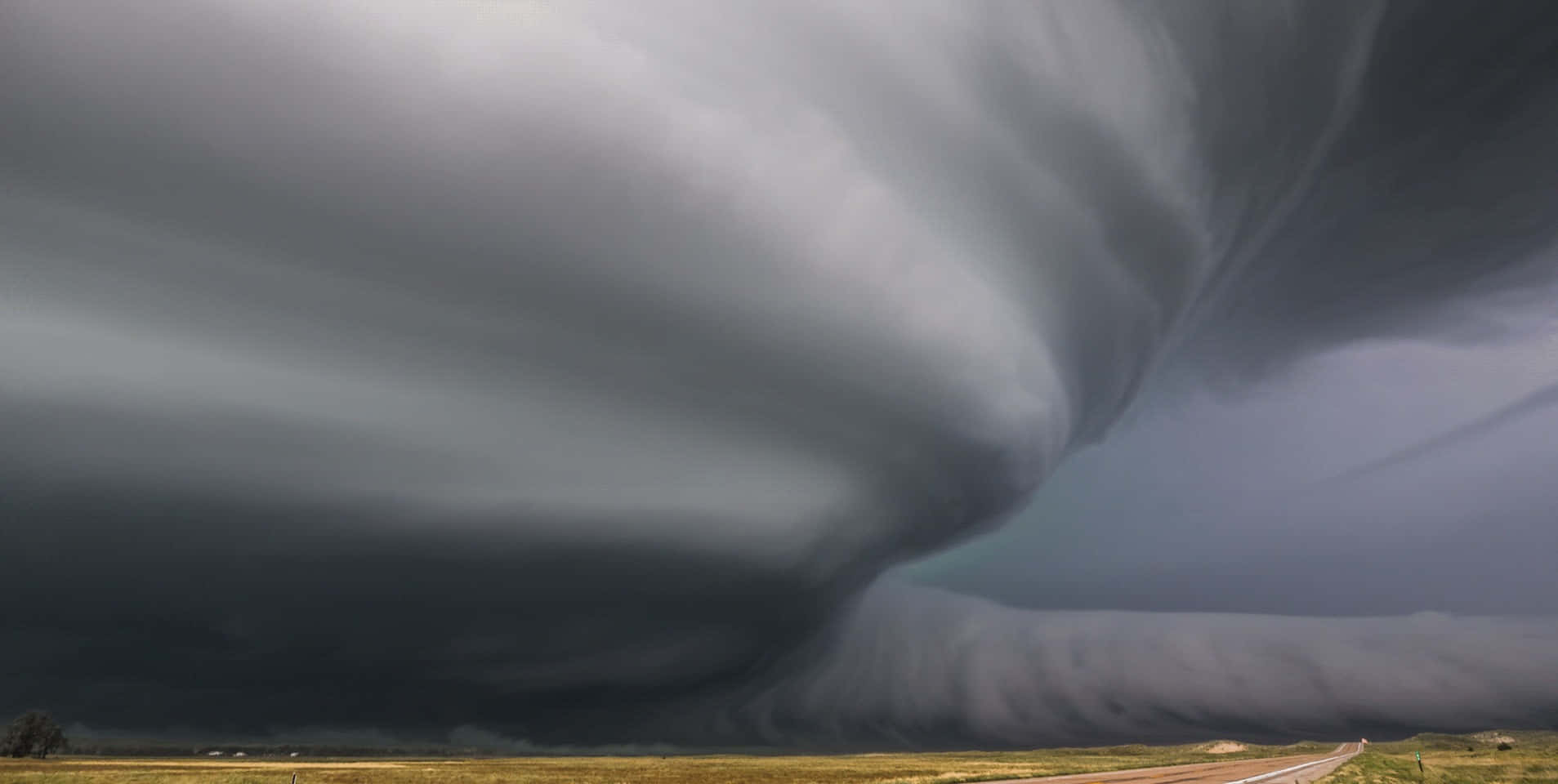 A powerful tornado touching down on a rural landscape.