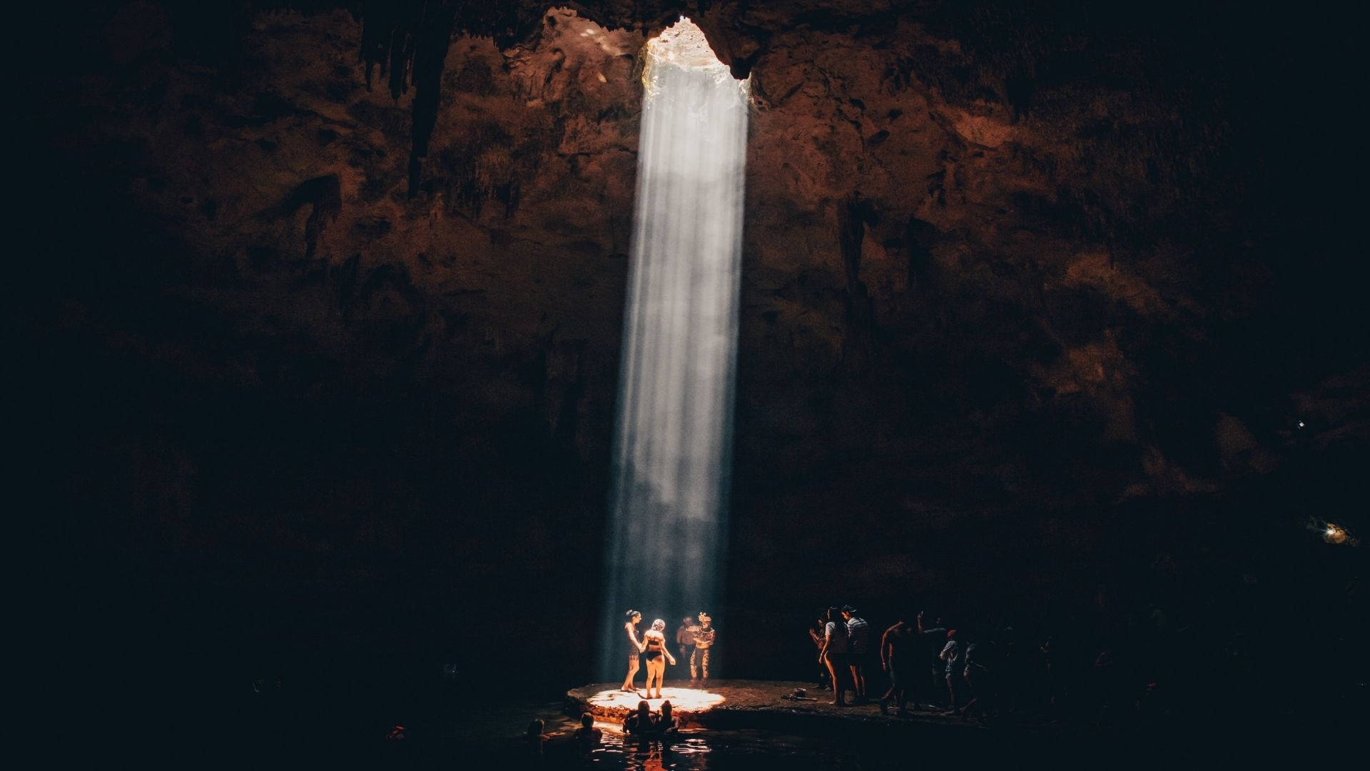 A group of tourists exploring an impressive natural cave Wallpaper