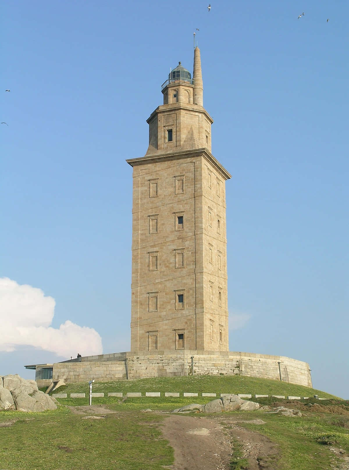 Tårnet af Hercules står højt under blå himmel. Wallpaper