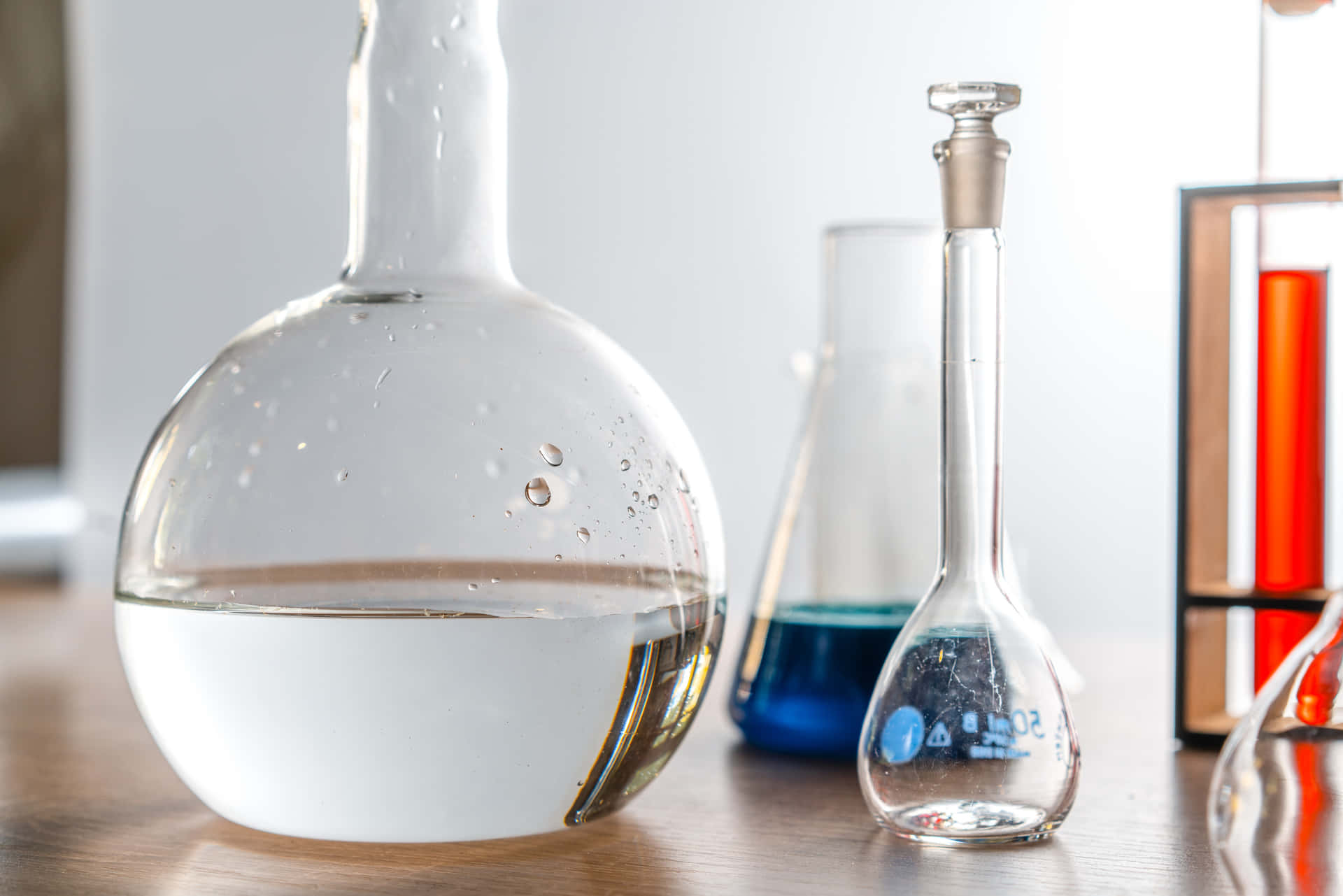A Group Of Laboratory Flasks And A Glass Of Water Wallpaper