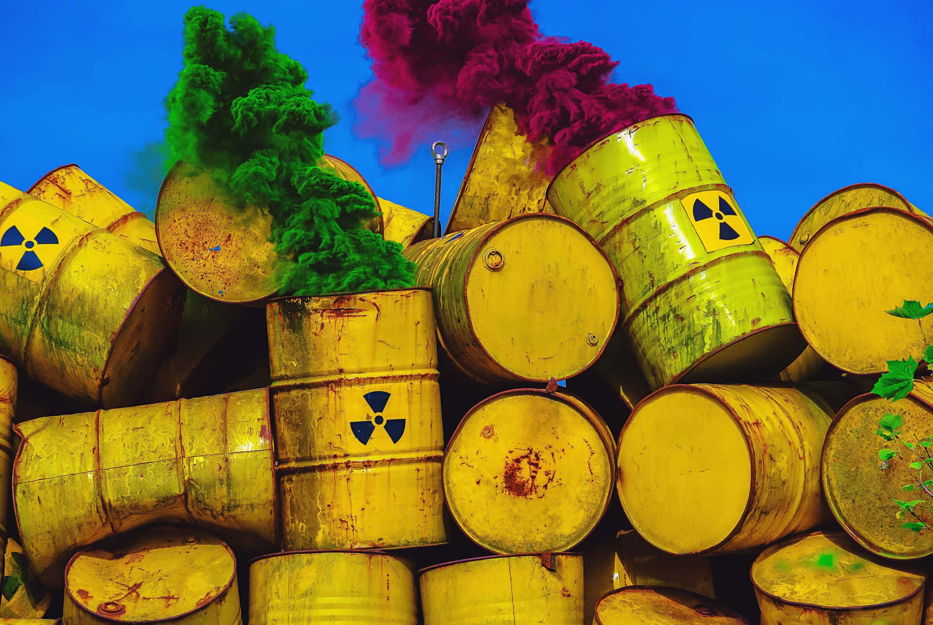 A Pile Of Yellow Barrels With Colored Smoke Wallpaper