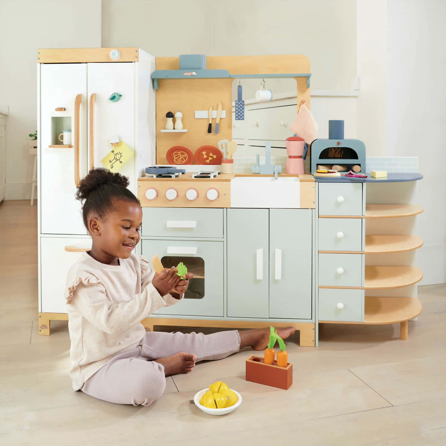 A Girl Playing With A Wooden Kitchen Set