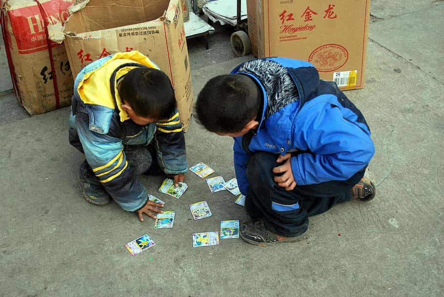 Tvåpojkar Spelar Kort På Gatan